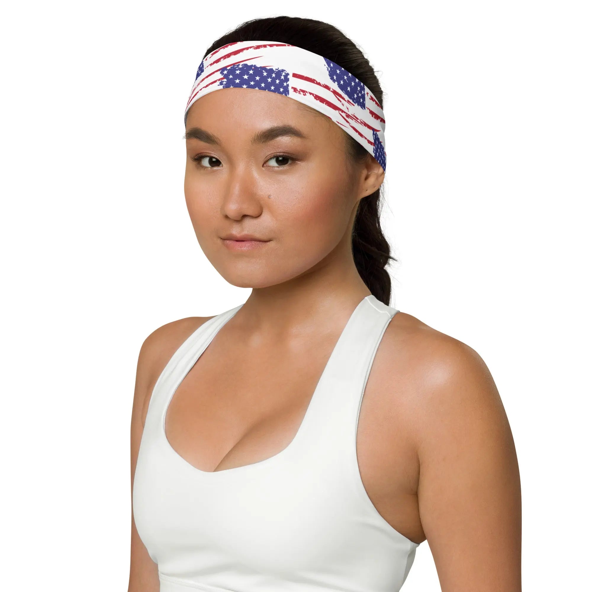 Woman wearing a white tank top and an American flag headband on a white background