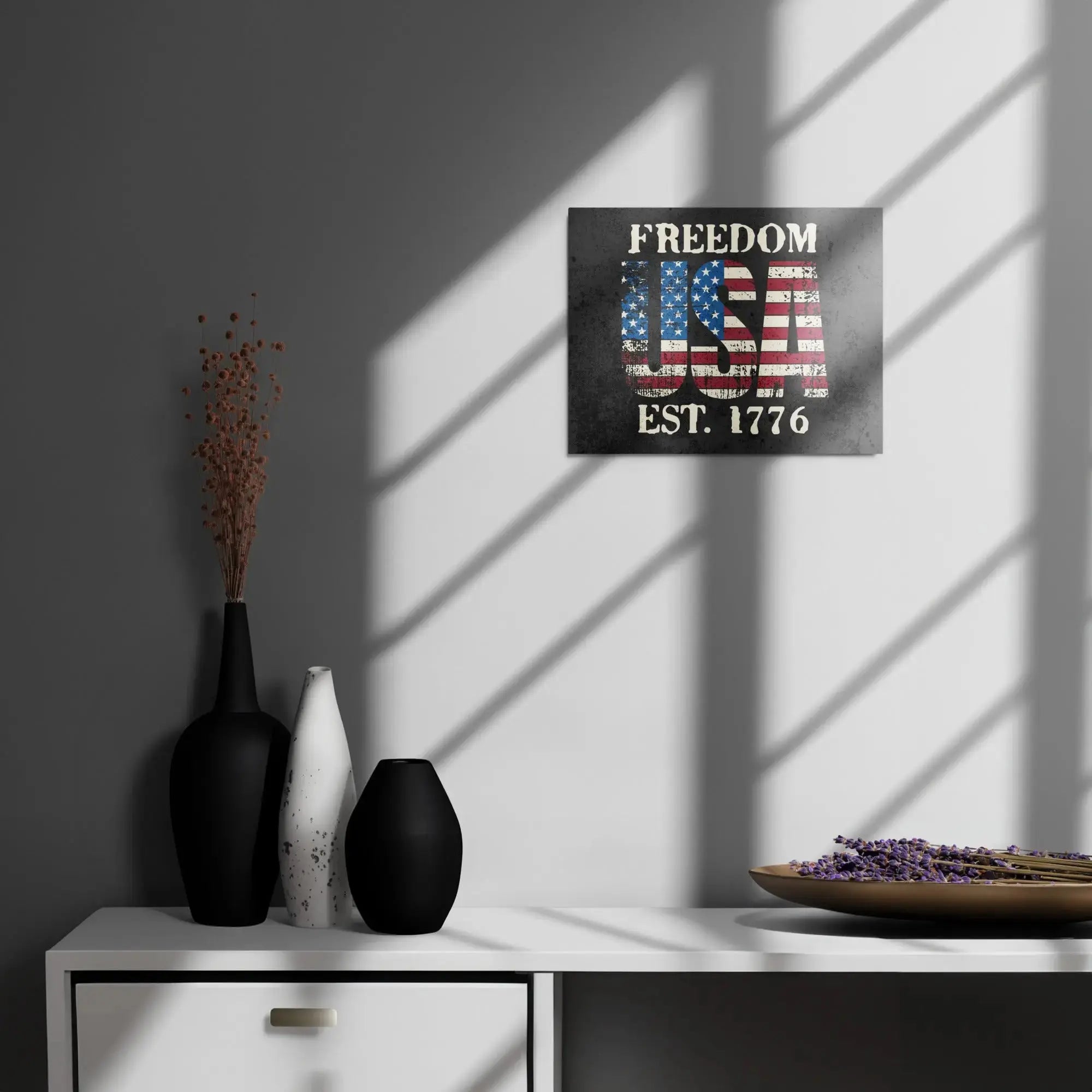 Patriotic metal sign hang on a wall with the American flag in the shape of USA and the text " Freedom Est. 1776" 