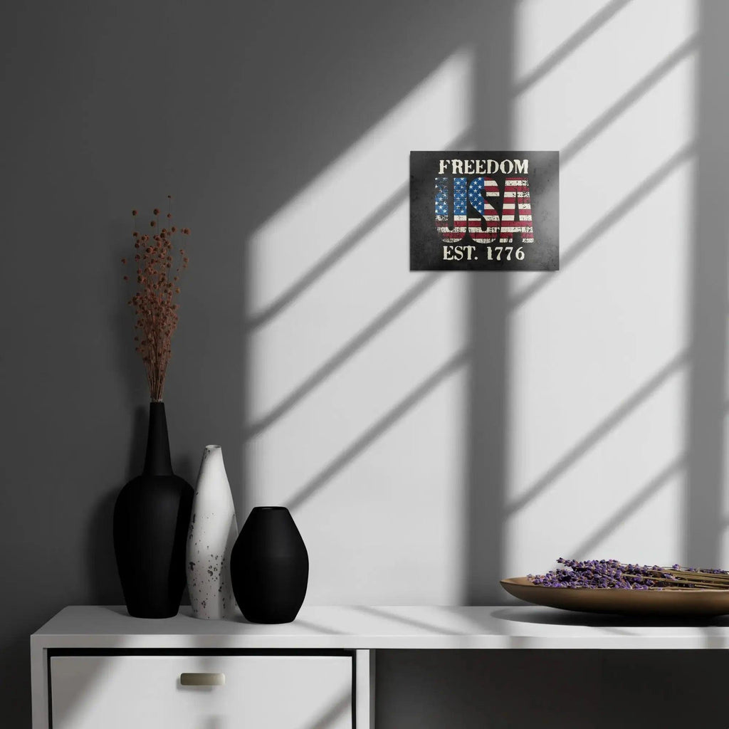 Patriotic metal sign hang on a wall with the American flag in the shape of USA and the text " Freedom Est. 1776" 