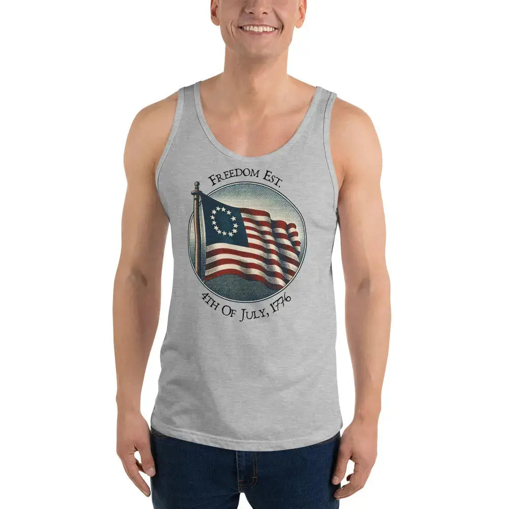 A man wearing a athletic heather patriotic tank top with the American flag and the text "Freedom Est. 4th of July, 1776."