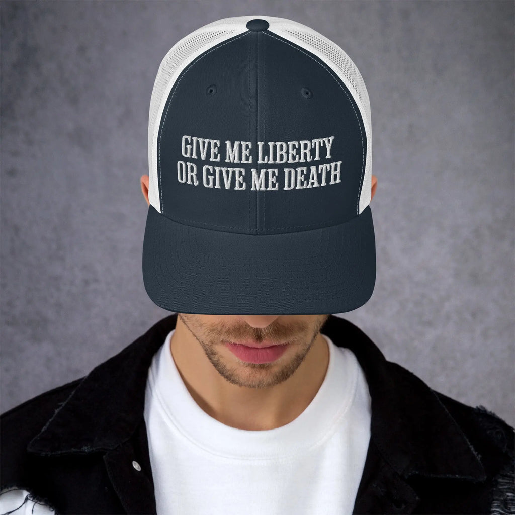 A man wearing a navy and white patriotic trucker hat with the text "Give Me Liberty Or Give Me Death."