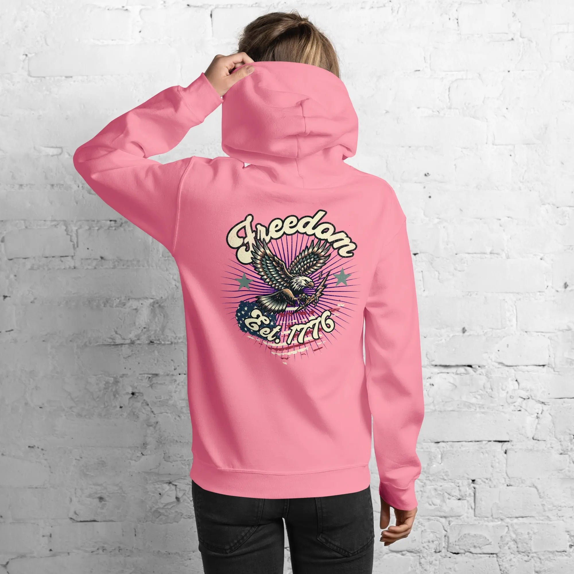 Back of woman wearing a azalea colored patriotic hoodie with an eagle and the text "Freedom Est. 1776" 