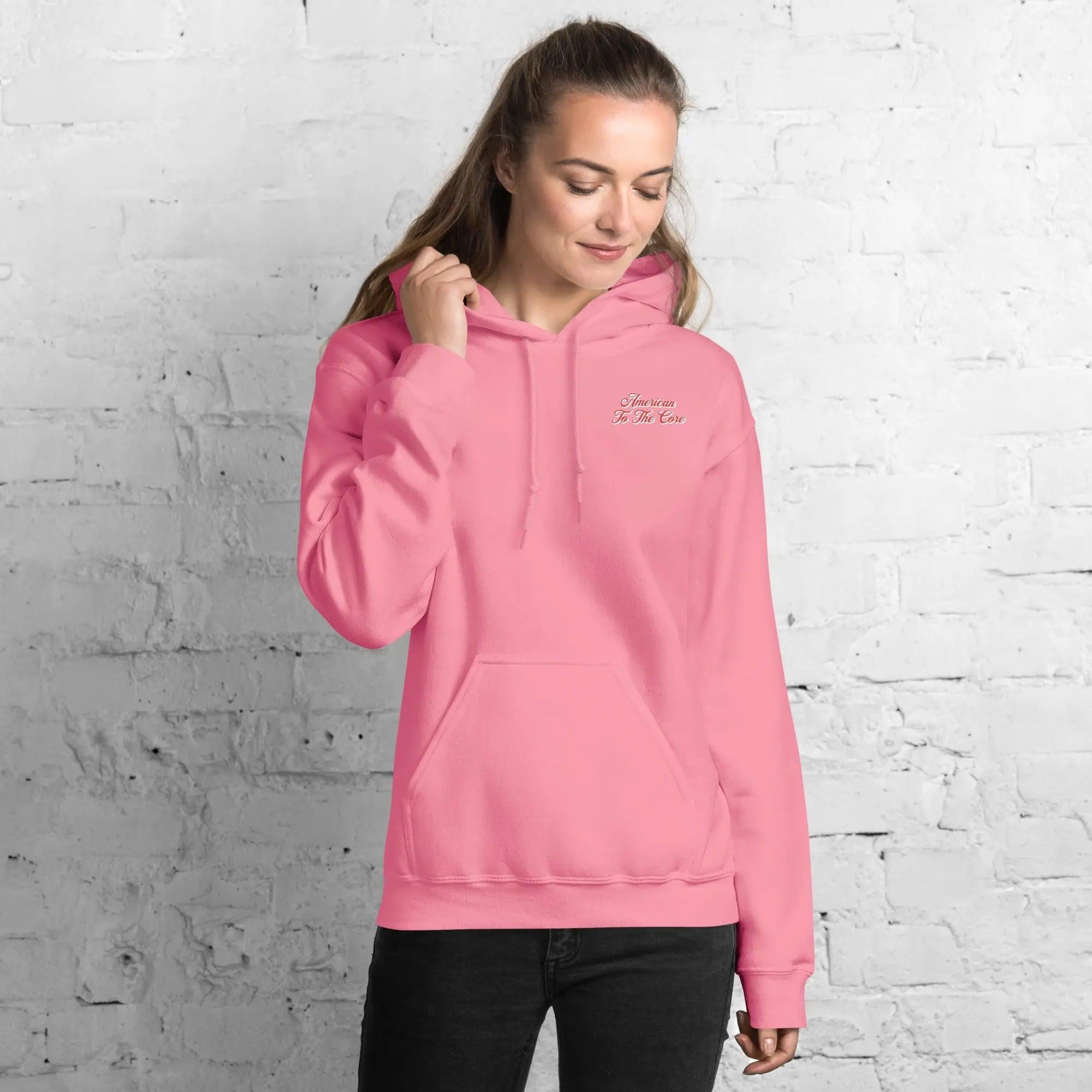 A woman wearing a azalea, patriotic hoodie with the text "American to the core."