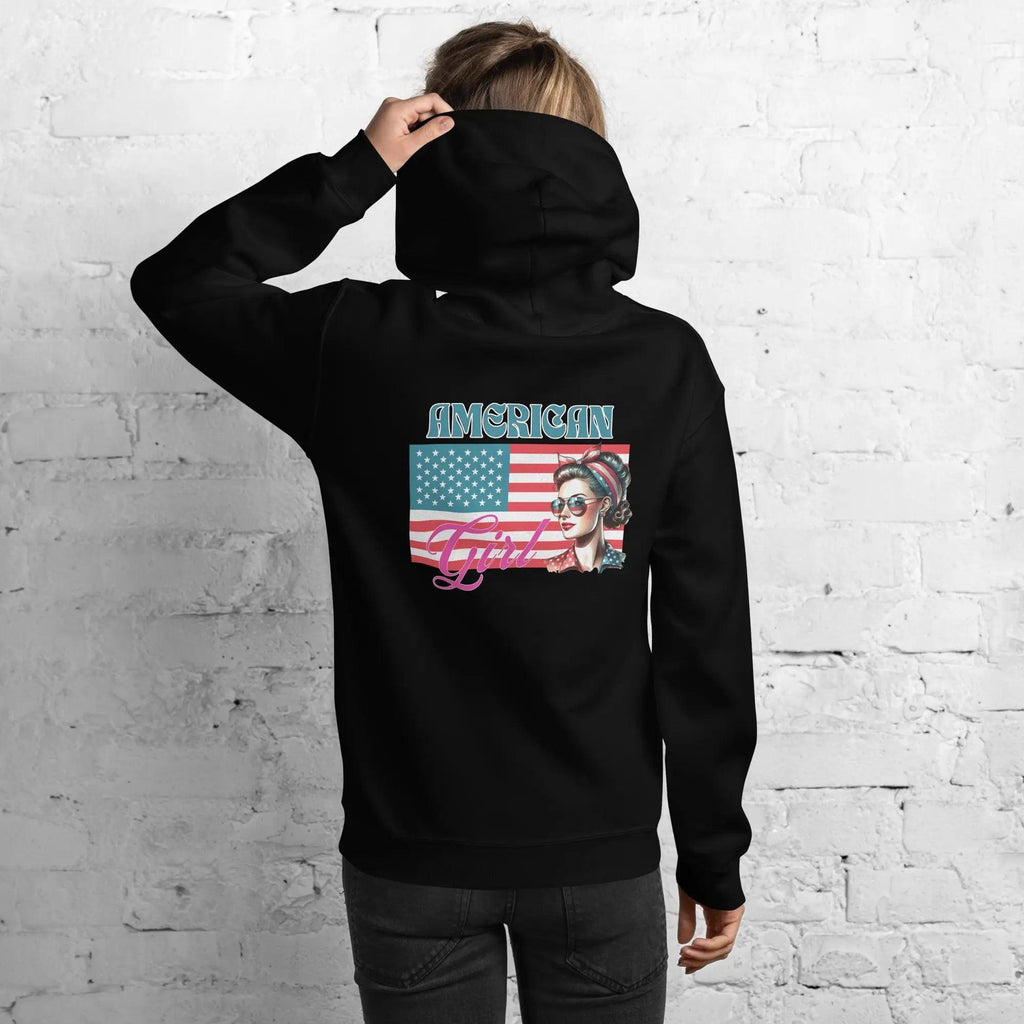 Back of woman wearing a patriotic black hoodie with a girl's head over the flag with the text "American Girl"
