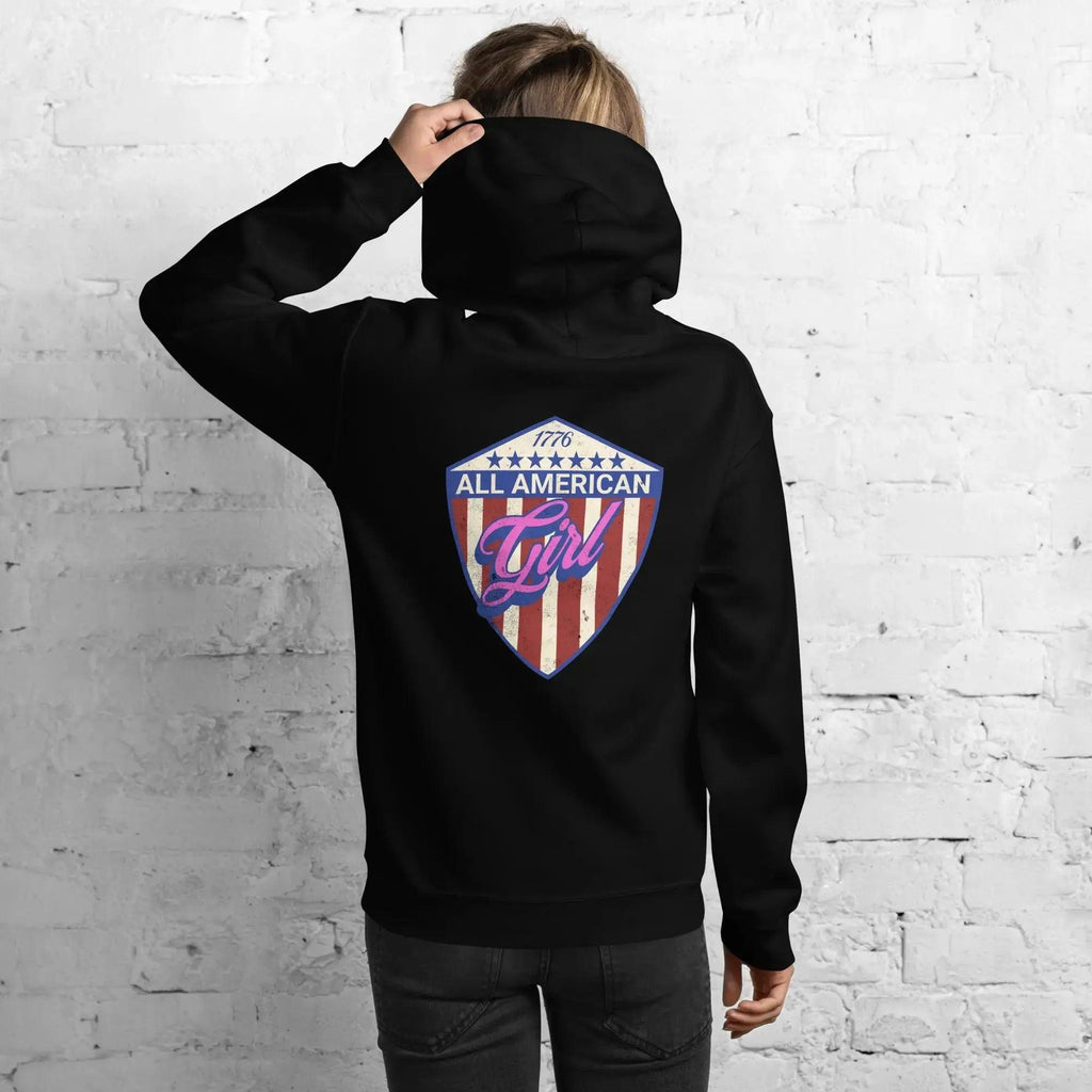 Back of a woman wearing a patriotic black hoodie with the text "All American Girl" over a patriotic design. 