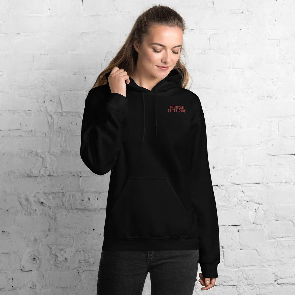 A woman wearing a black, patriotic hoodie with the text "American to the core" in red