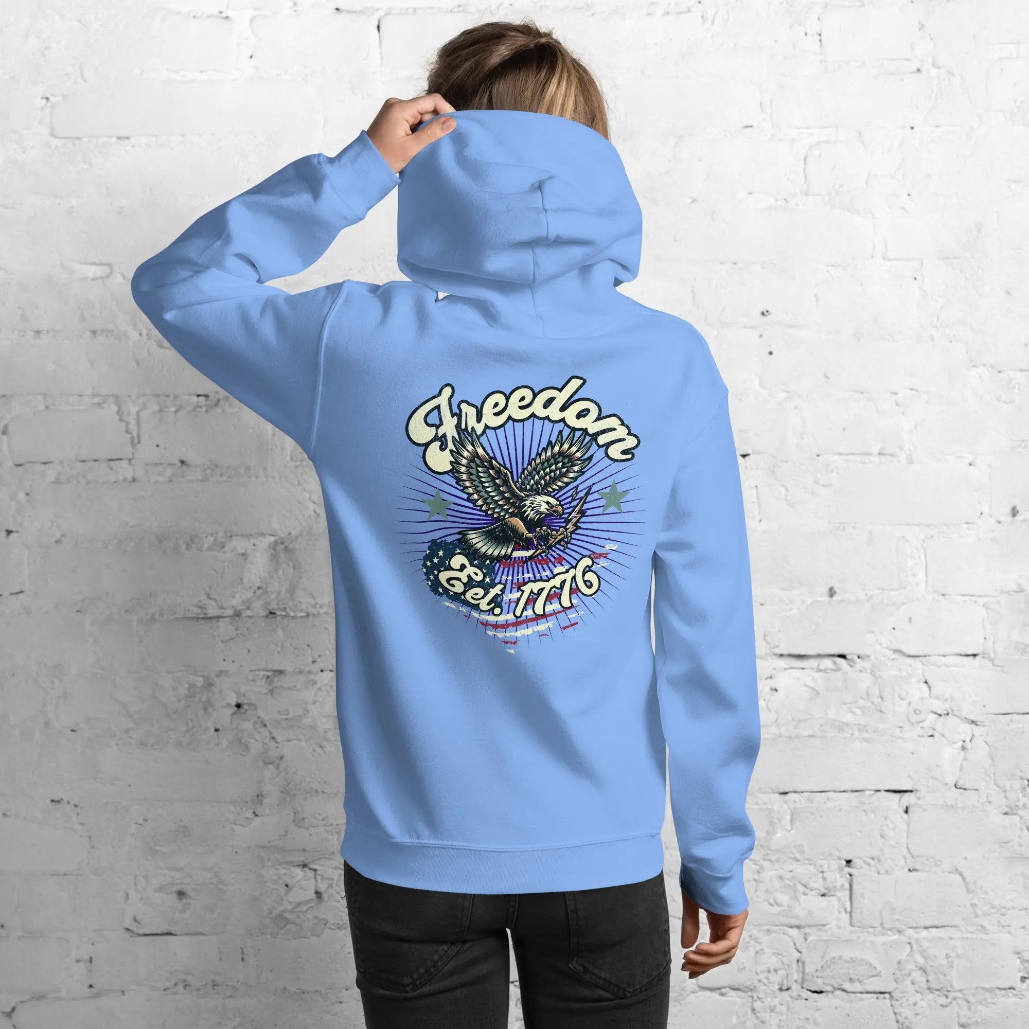 Back of woman wearing a carolina blue patriotic hoodie with an eagle and the text "Freedom Est. 1776" 