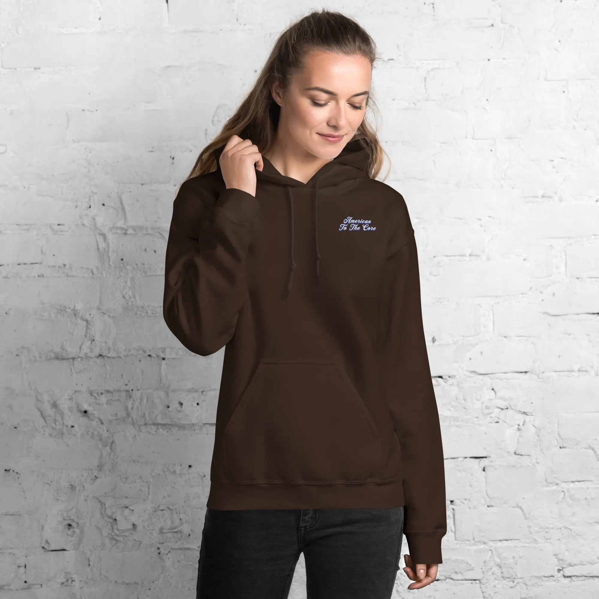 A woman wearing a patriotic dark chocolate hoodie with the text "American to the core."