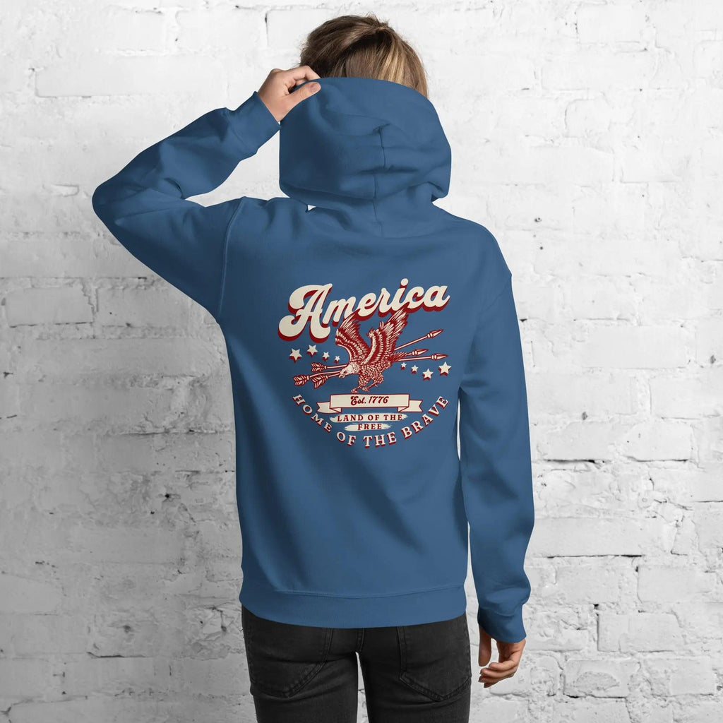 Back of a woman wearing an indigo blue patriotic hoodie with an eagle and the text "America, home of the brave."