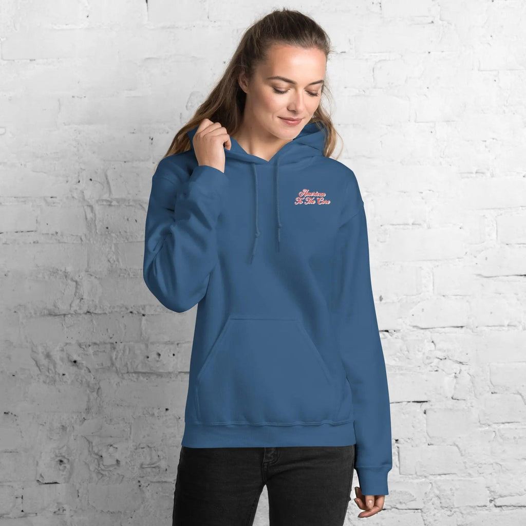 A woman wearing a indigo blue, patriotic hoodie with the text "American to the core."