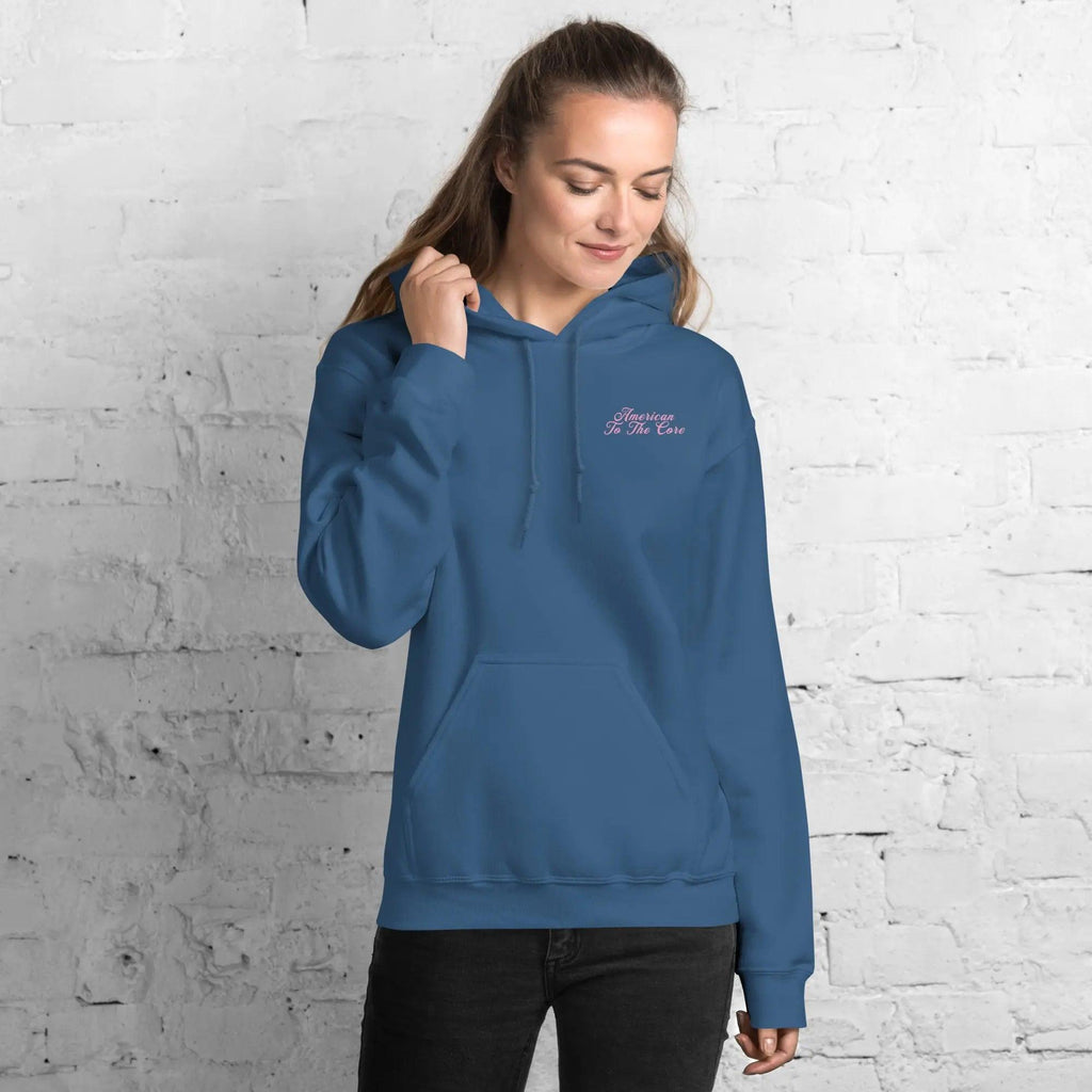 A woman wearing a indigo blue patriotic hoodie with the text "American To The Core"