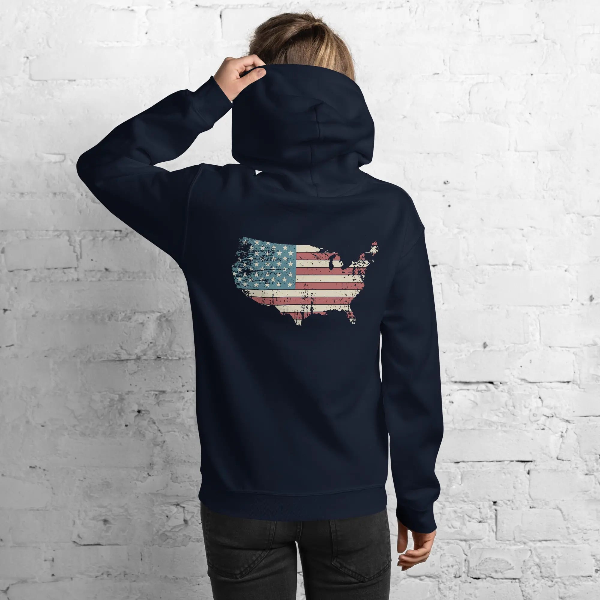 Back of a woman wearing a navy patriotic hoodie with a silhouette of America with the flag in it. 