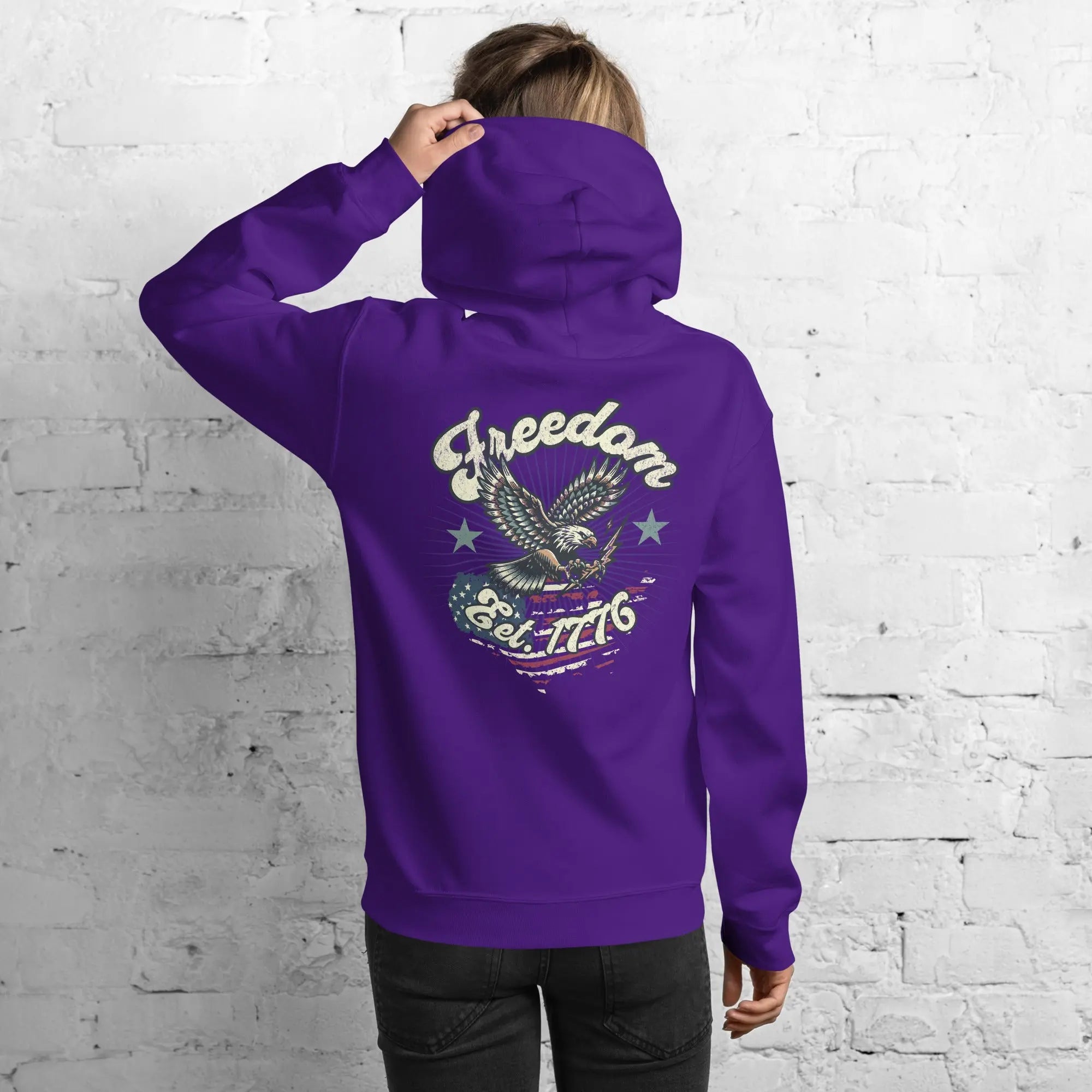 Back of woman wearing a purple patriotic hoodie with an eagle and the text "Freedom Est. 1776" 