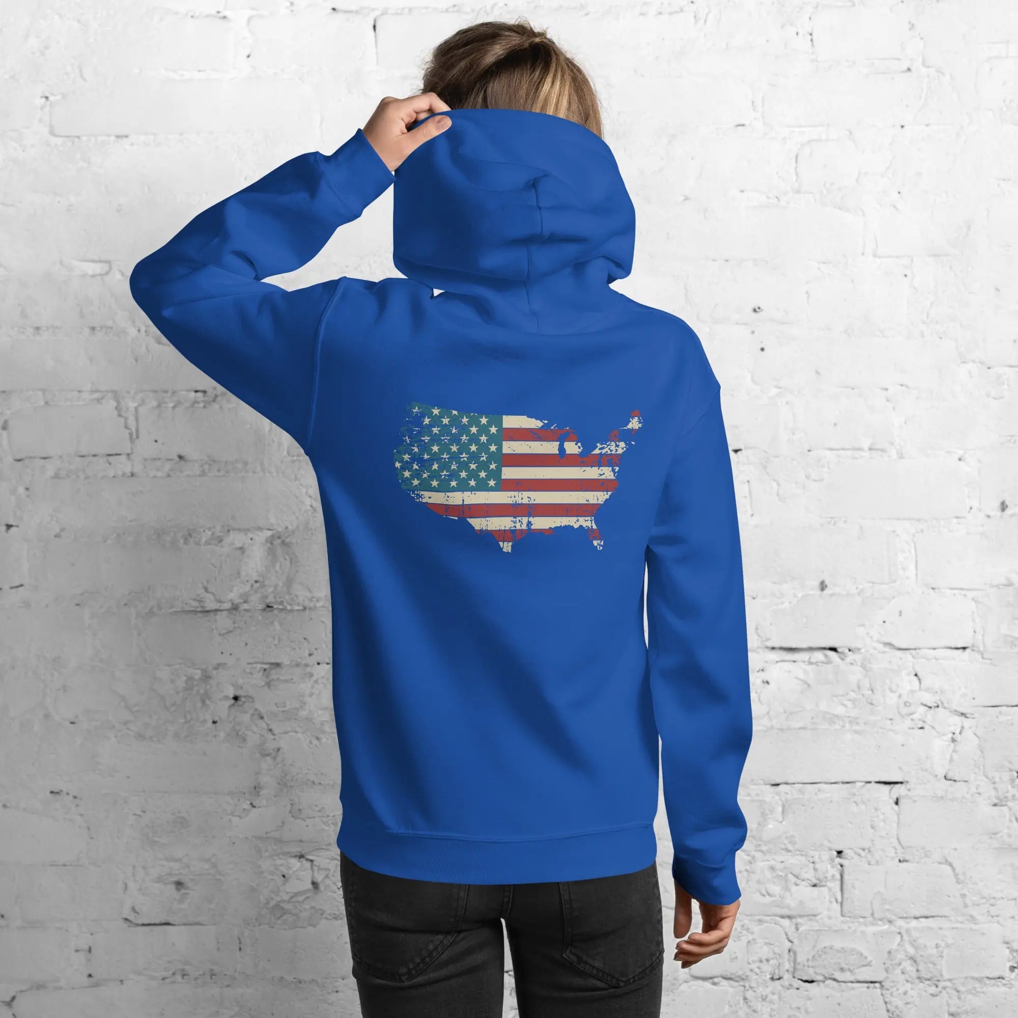 Back of a woman wearing a royal blue patriotic hoodie with a silhouette of America with the flag in it. 