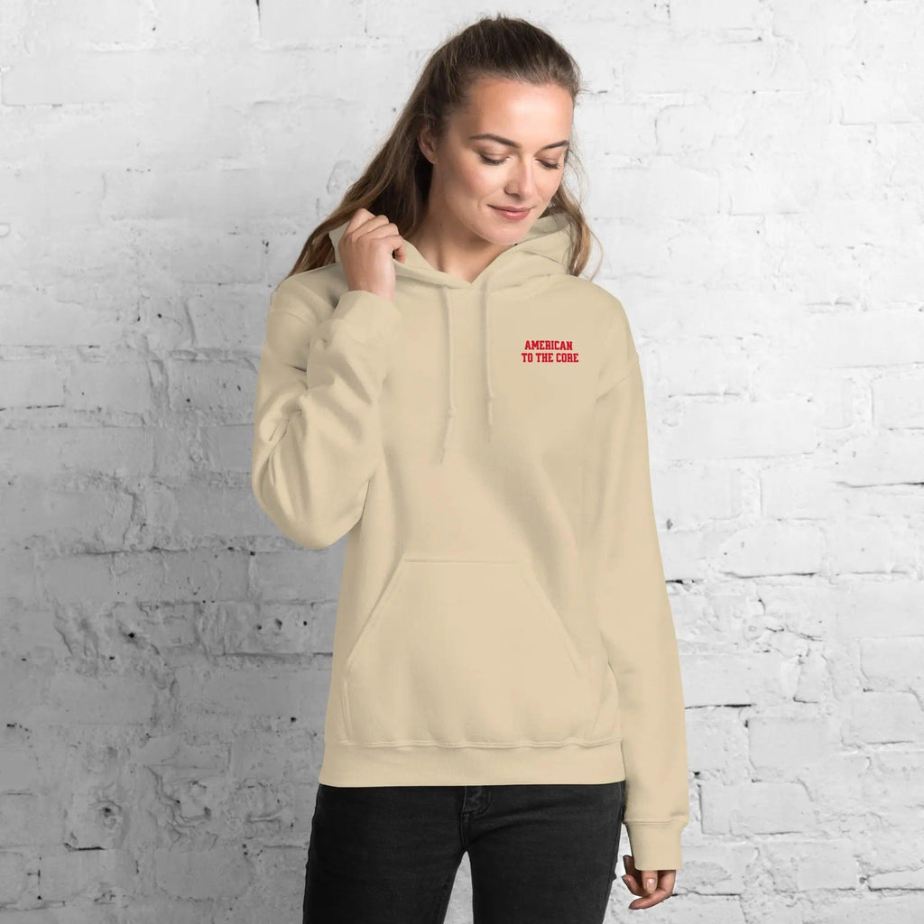 A woman wearing a sand hoodie with the text "American to the core"