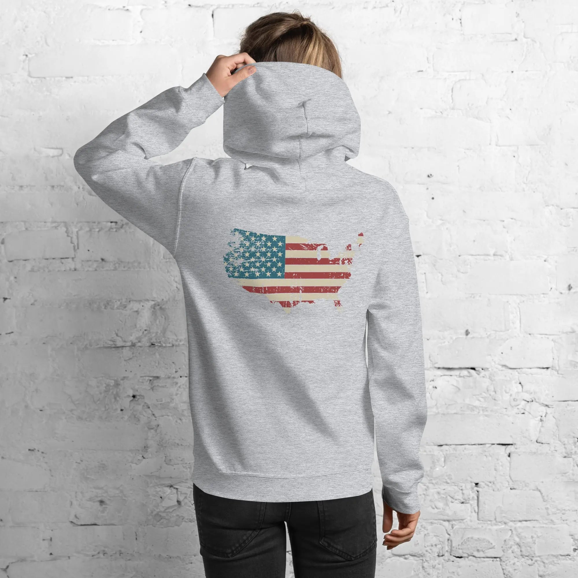Back of a woman wearing a sport grey patriotic hoodie with a silhouette of America with the flag in it. 