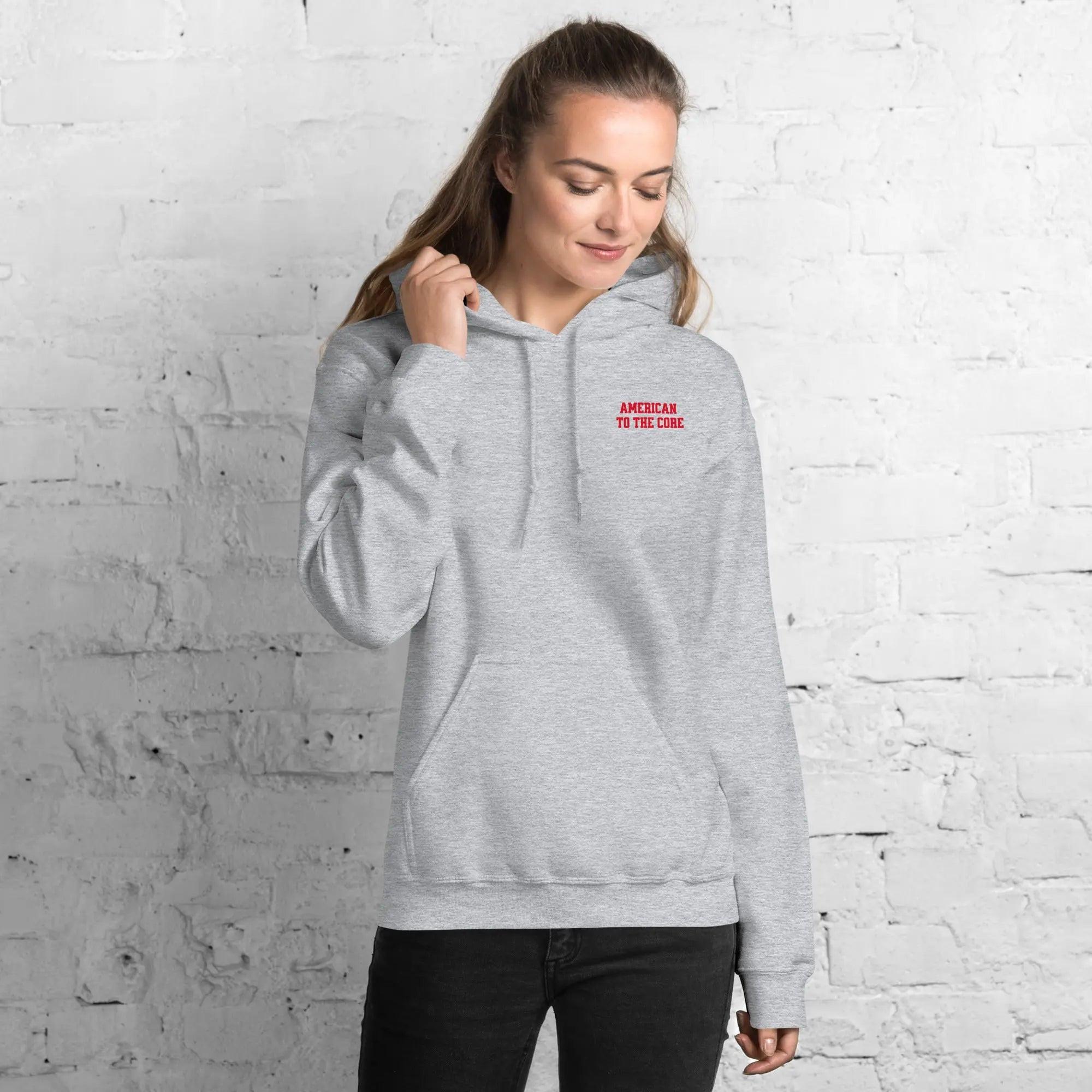 A woman wearing a sport grey hoodie with the text "American to the core"