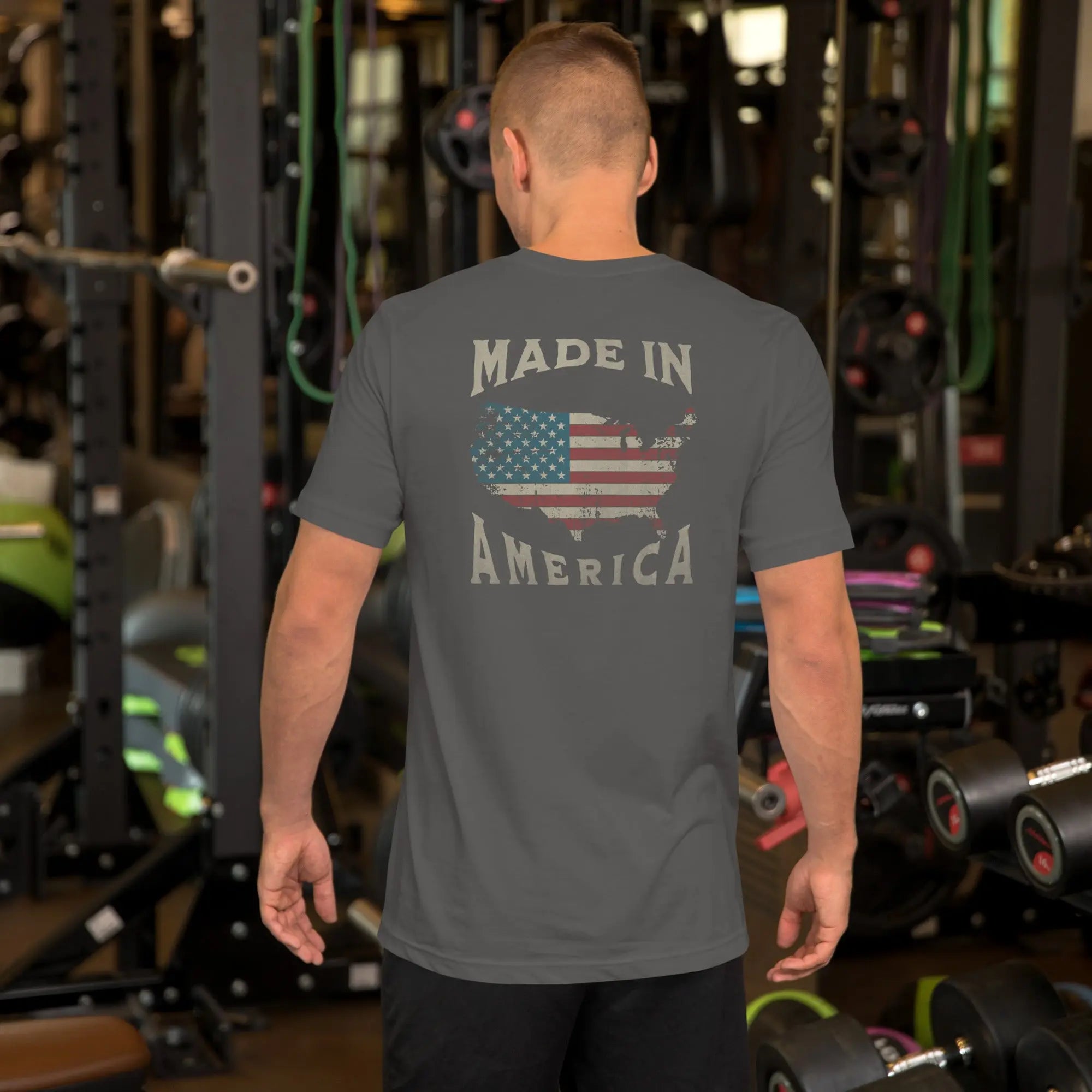 A man wearing a gray patriotic t-shirt with "Made in America" text. A silhouette of America with the American flag in it. 