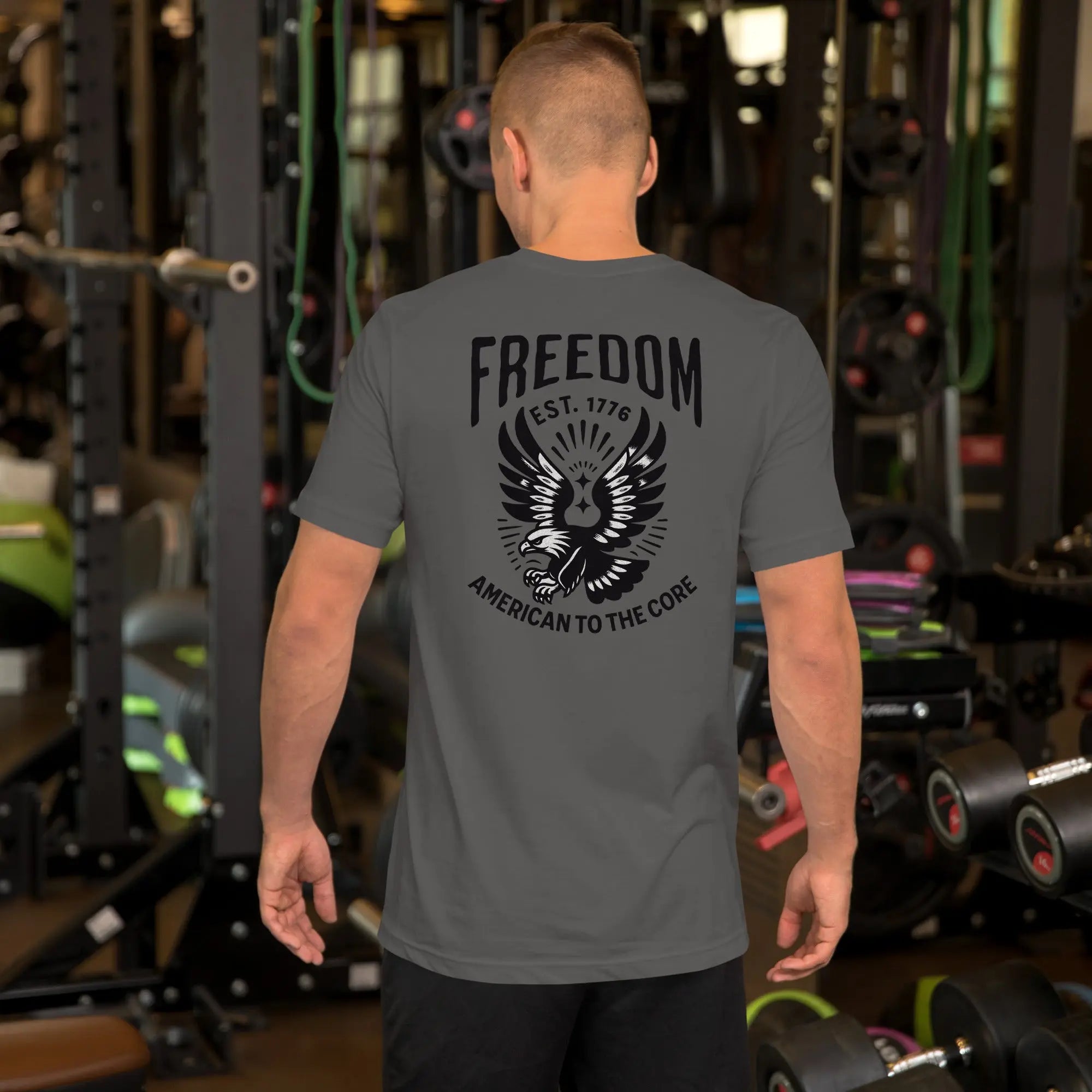 Back of man wearing a asphalt patriotic t-shirt with an eagle and "freedom est. 1776" text