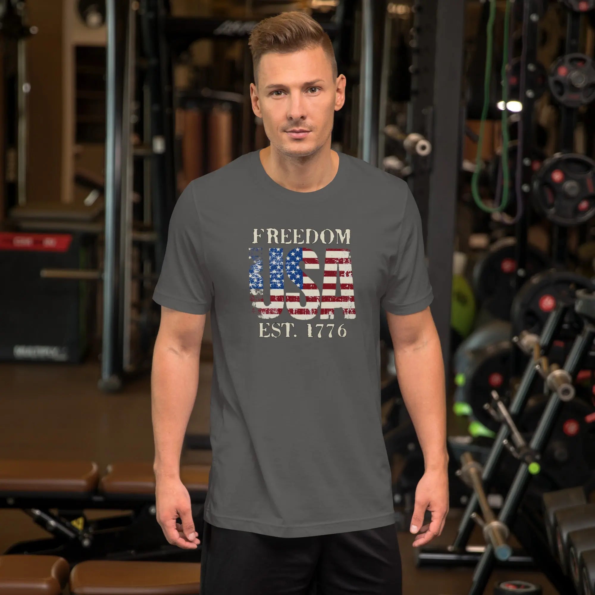 a man wearing a gray patriotic t-shirt with "Freedom USA Est. 1776" text.