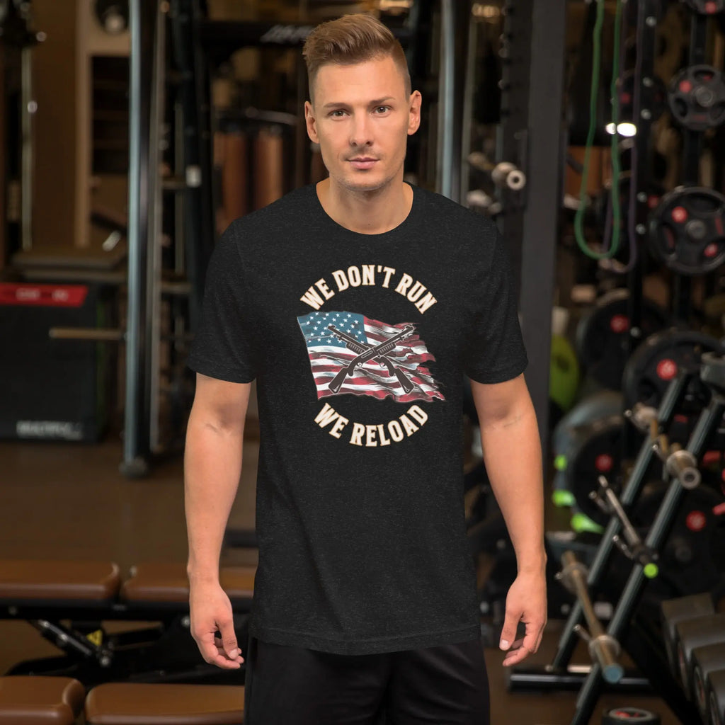 A man wearing a black heather patriotic t-shirt with shotguns over the American flag and the "We don't run, we reload" text.