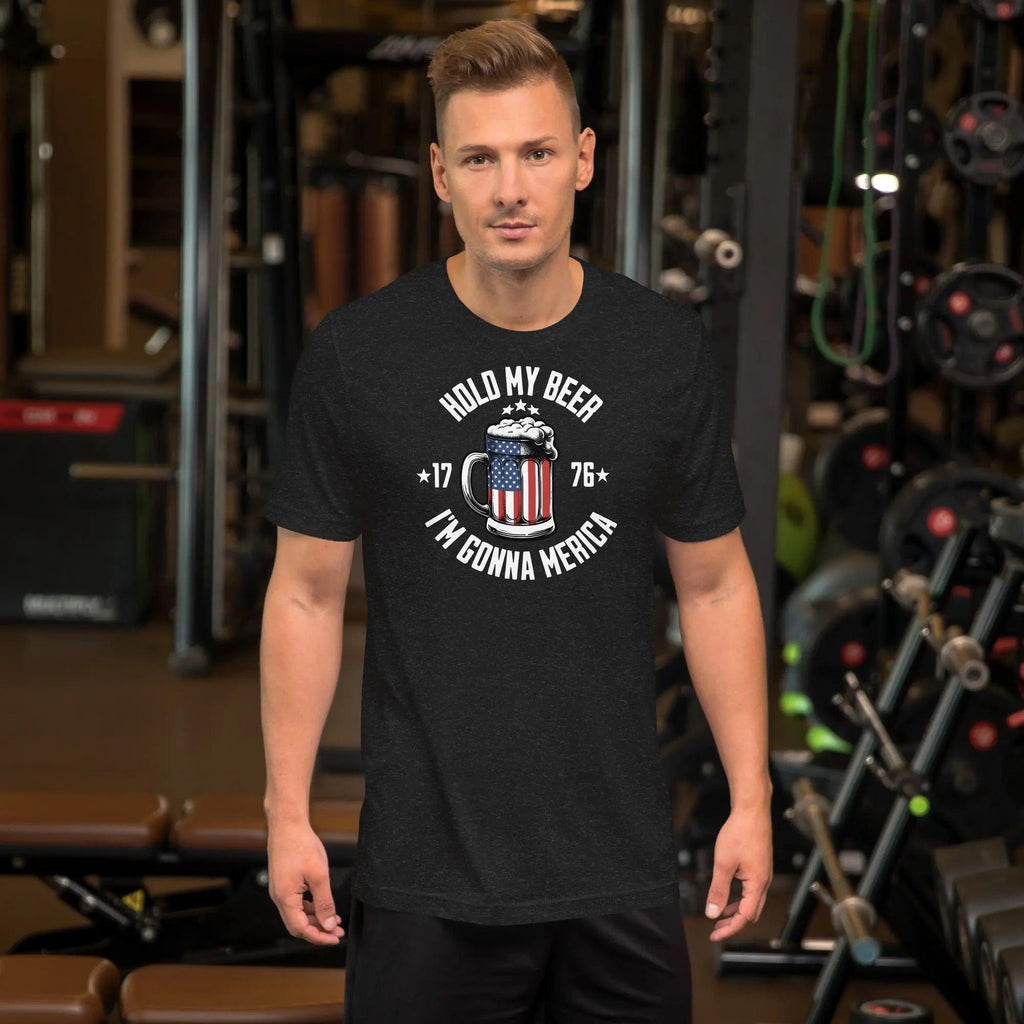 A man wearing a black heather patriotic t-shirt with an American flag beer mug with the text "Hold My Beer I'm Gunna Merica."