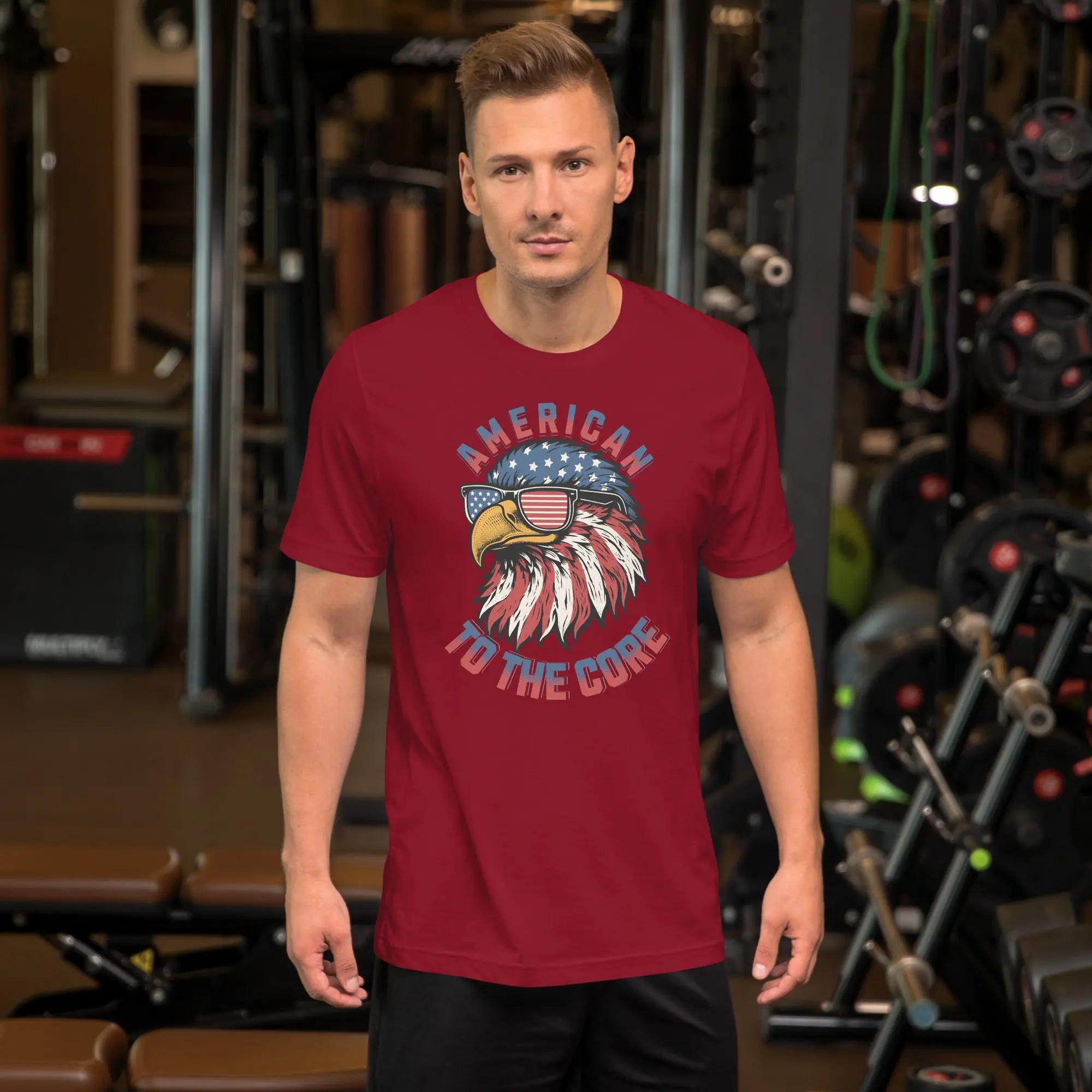 A man wearing a red patriotic t-shirt with an eagle head with "American to the core" text.