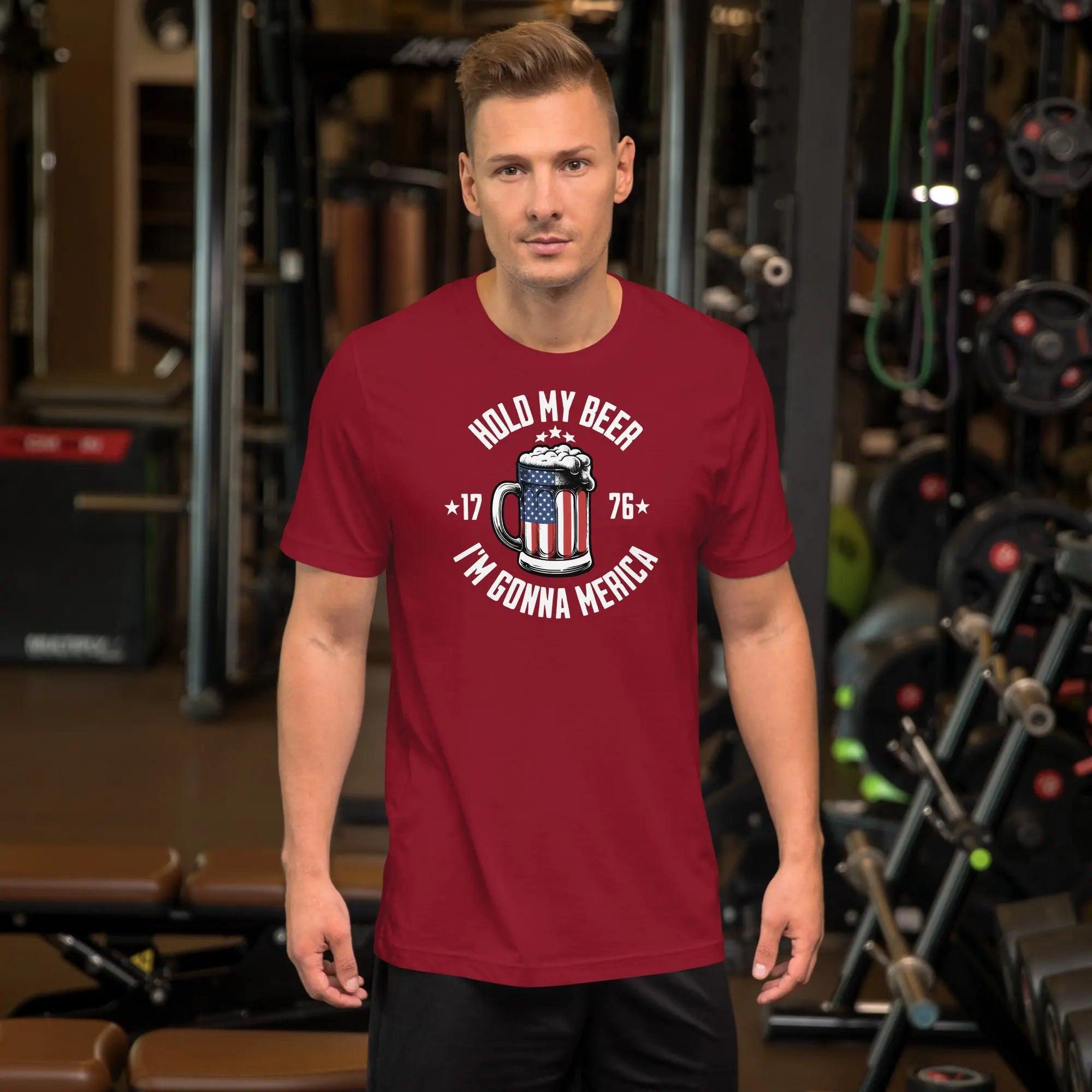 A man wearing a cardinal patriotic t-shirt with an American flag beer mug with the text "Hold My Beer I'm Gunna Merica."