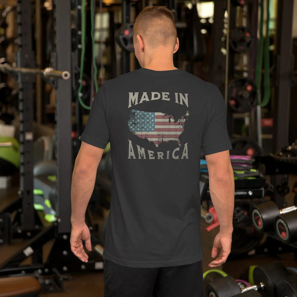man wearing a flat black patriotic t-shirt with "made in america" text. A silhouette of america with the american flag in it. 