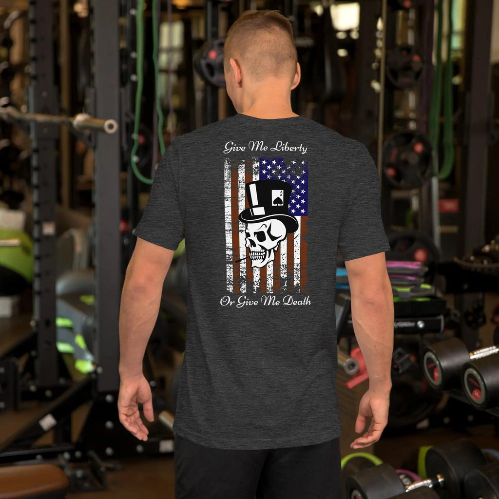 The back of a man wearing a dark grey heather patriotic T-shirt with a skull over the American flag and the text "Give Me Liberty or Give Me Death."