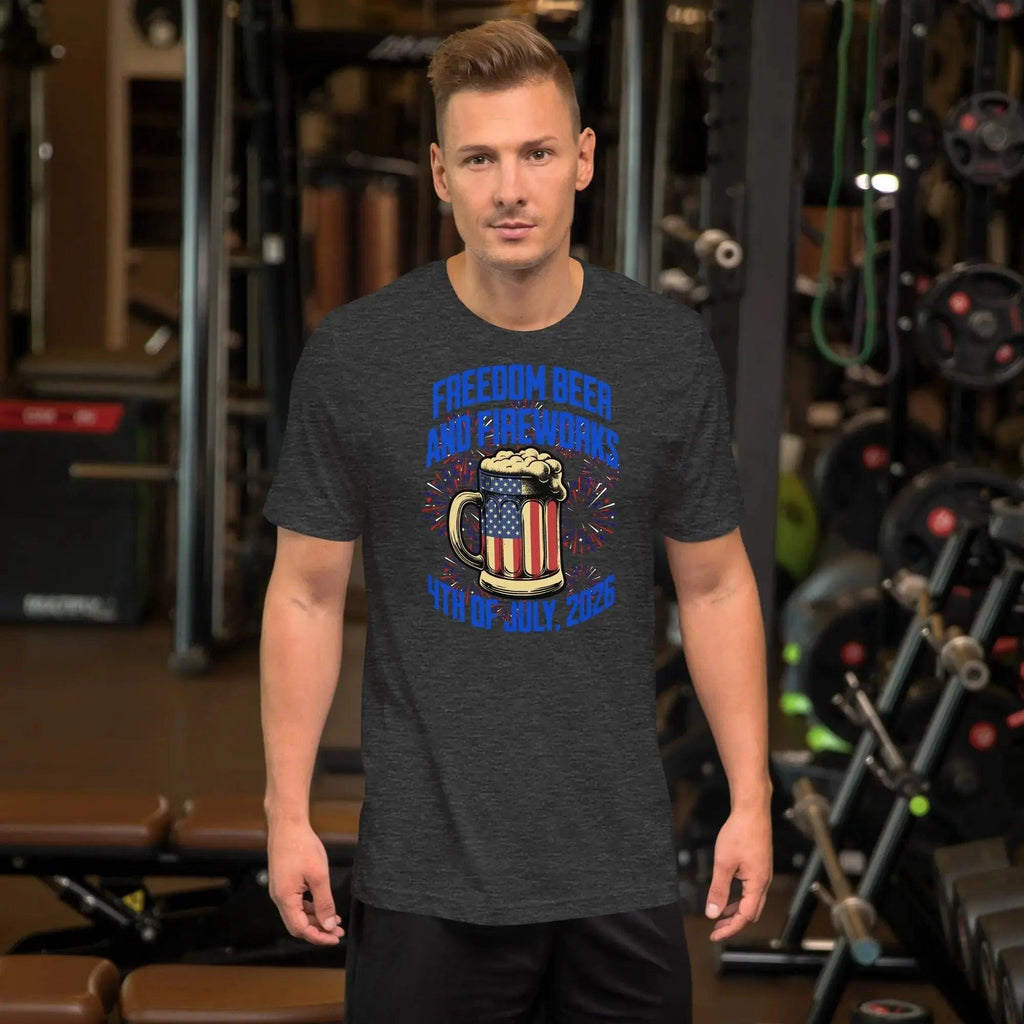 A man wearing a grey heather patriotic t-shirt with a beer mug and fireworks with the text "Freedom, Beer, and Fireworks" and "4th of July, 2026."