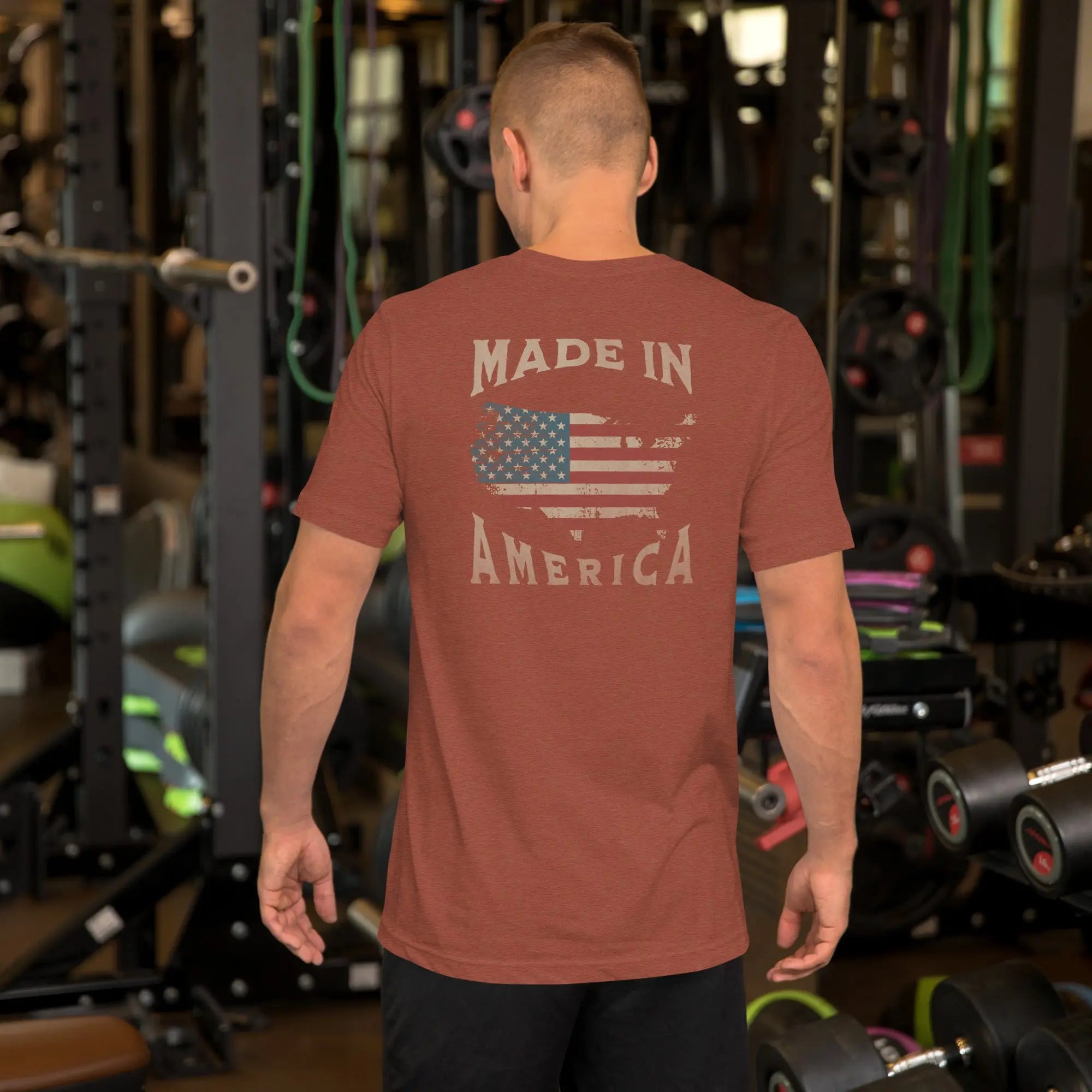 A man wearing a burnt orange patriotic t-shirt with "Made in America" text. A silhouette of America with the American flag in it. 