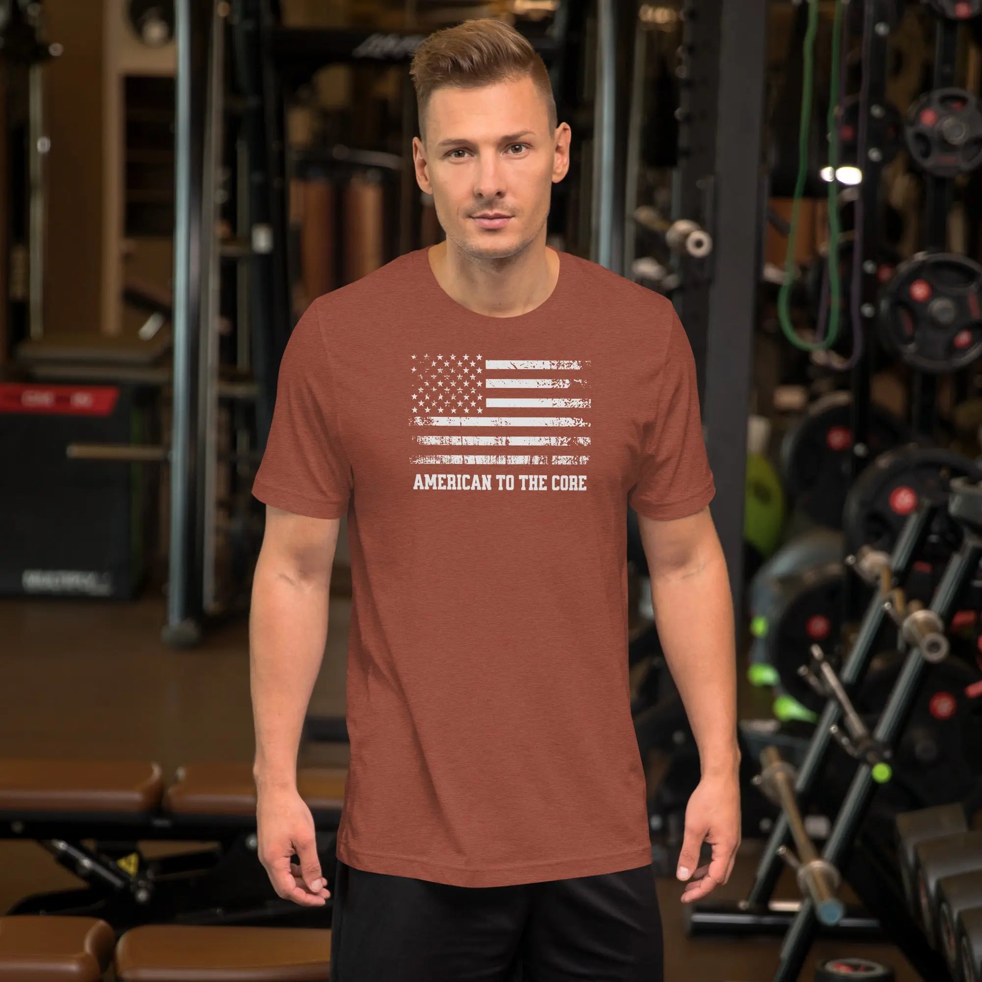 A man wearing a heather clay patriotic t-shirt with an American flag and "American to the core" text.