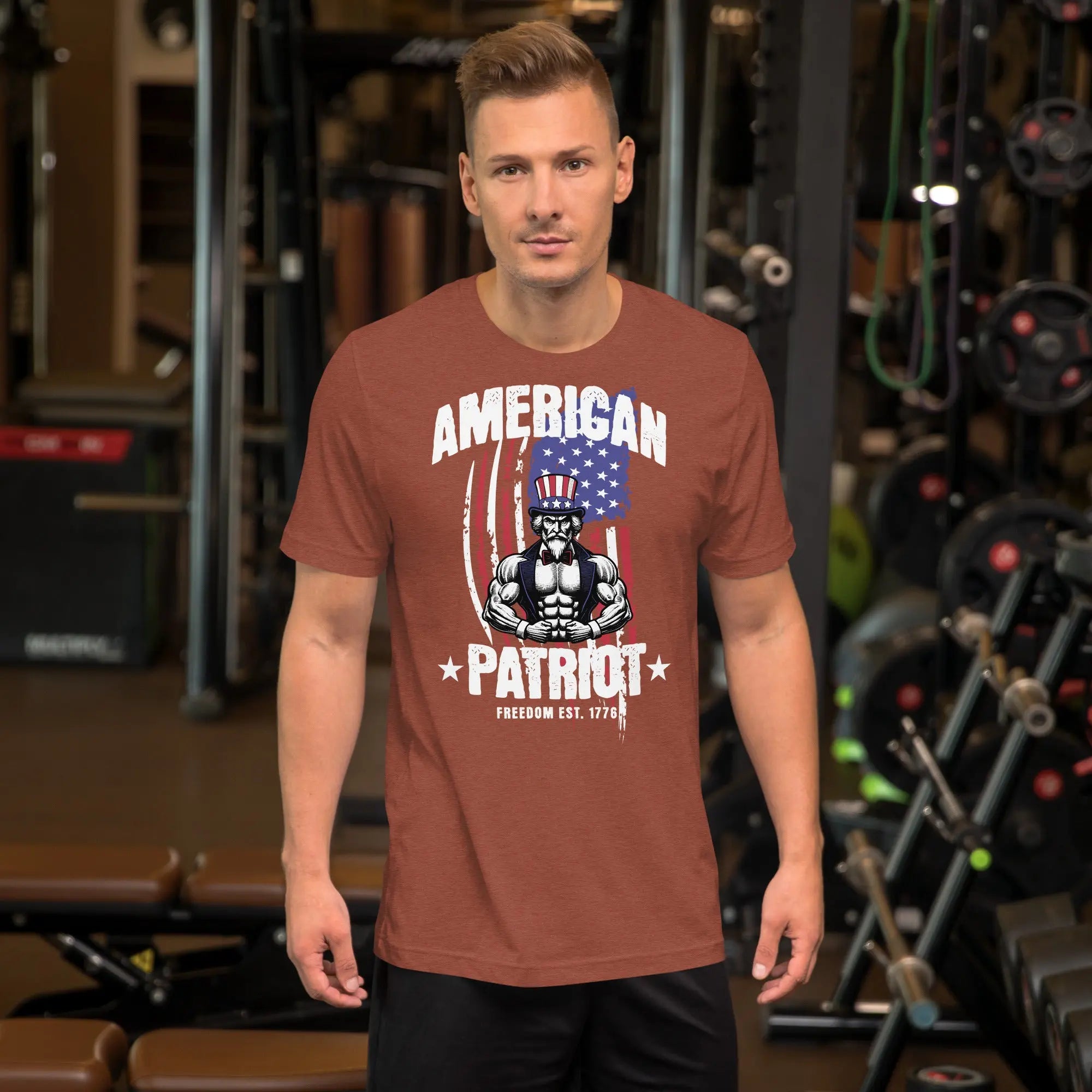 A man wearing a heather clay patriotic t-shirt with a muscular Uncle Sam with "American Patriot" text.