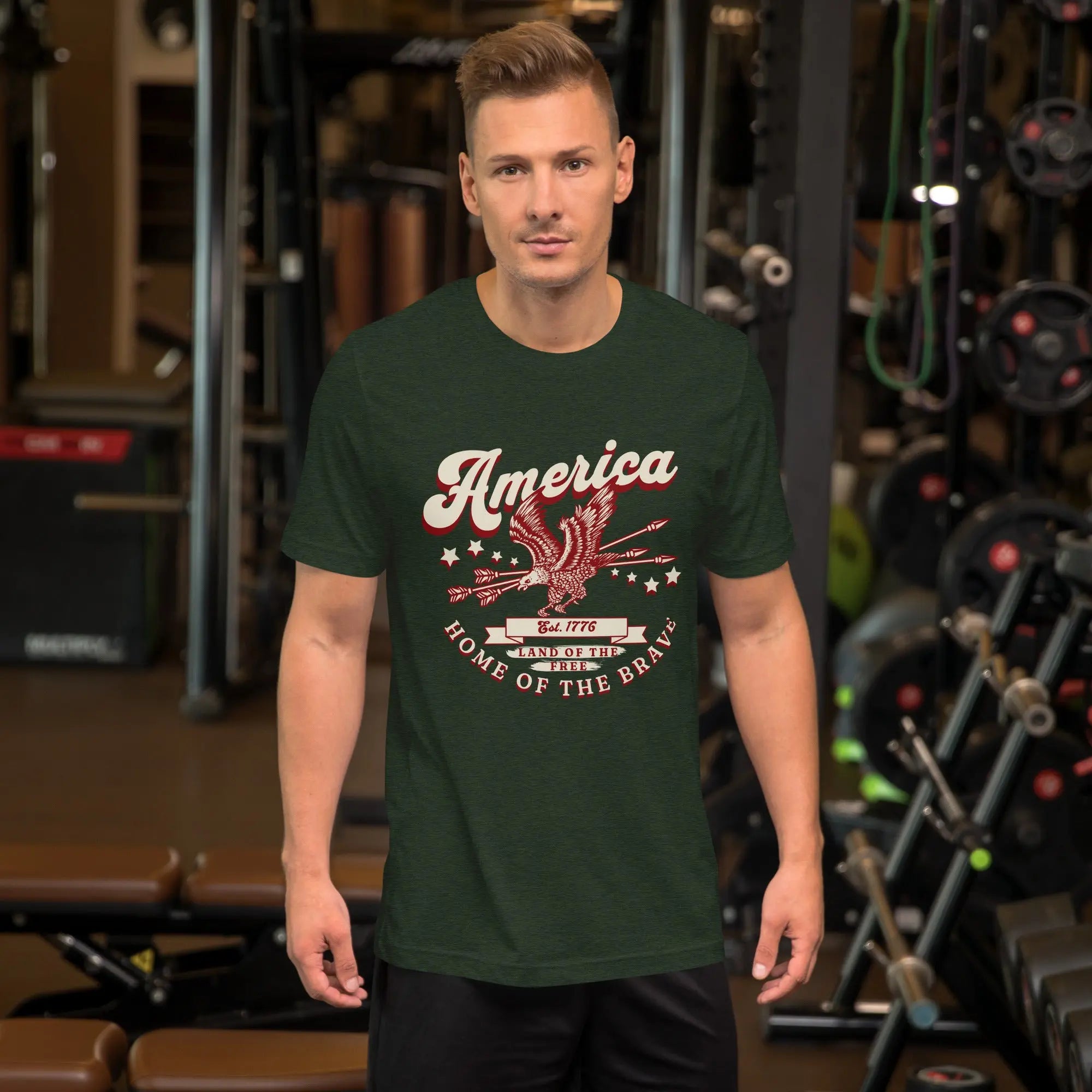A man wearing a heather emerald patriotic t-shirt with an eagle and "America Home Of The Brave" text.