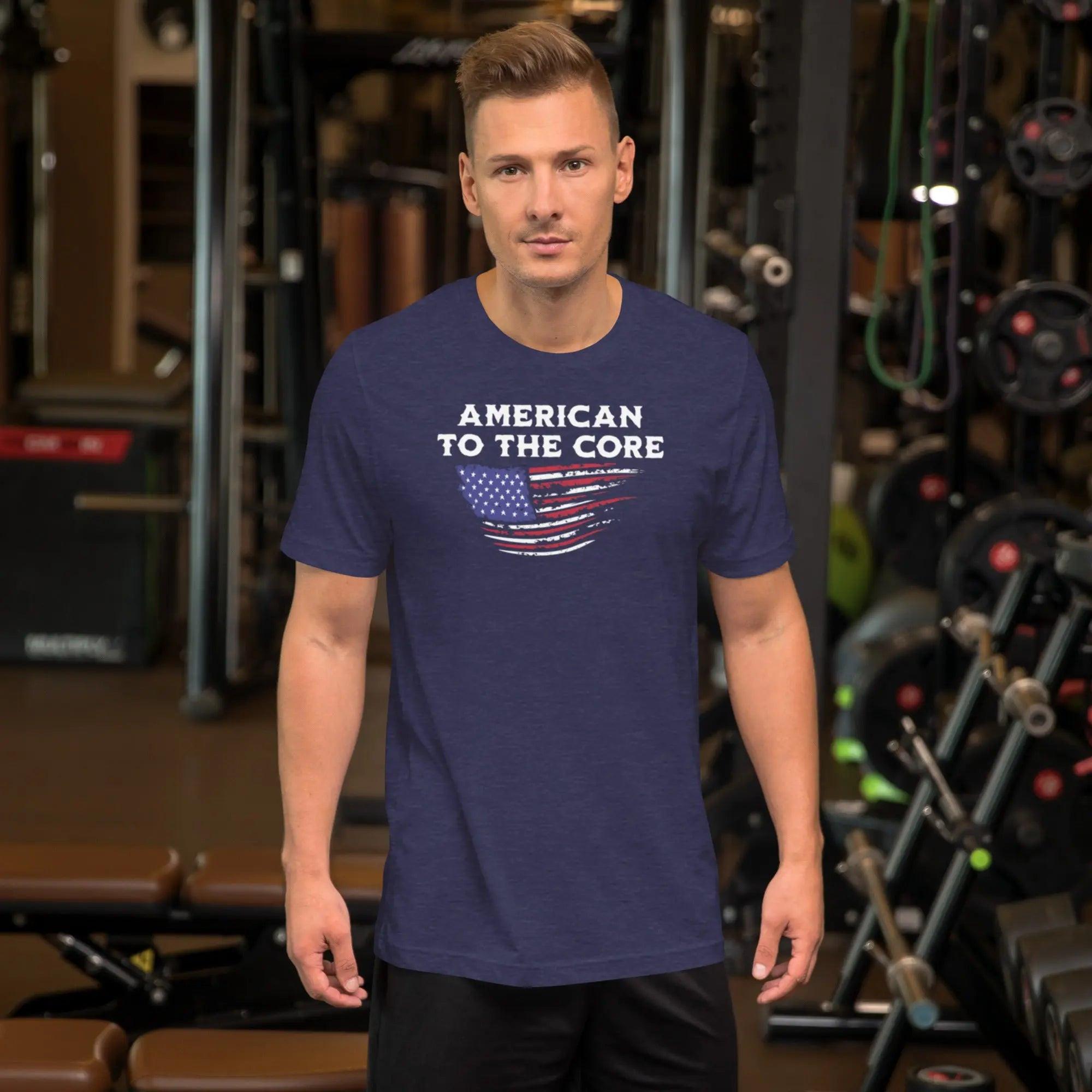 Man wearing a heather midnight navy patriotic t-shirt with the American flag and the text "American To The Core."