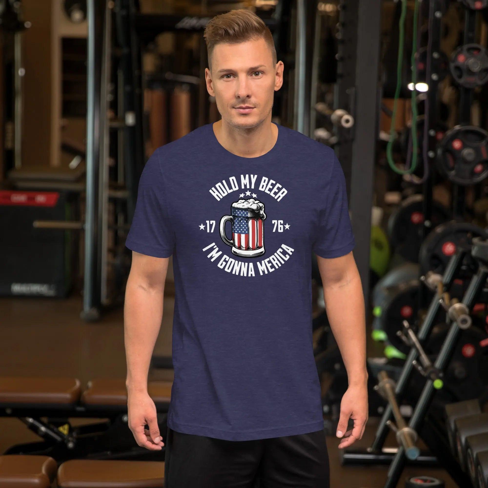 A man wearing a heather midnight navy patriotic t-shirt with an American flag beer mug with the text "Hold My Beer I'm Gunna Merica."