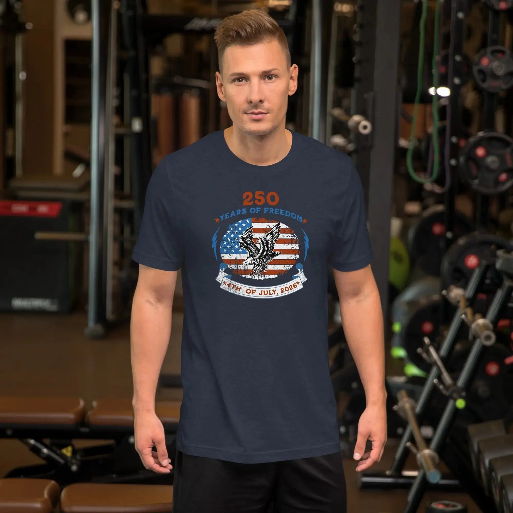 A man wearing a heather navy patriotic men's t-shirt with an eagle over the American flag and the text "250 years of freedom, 4th of July, 2026."