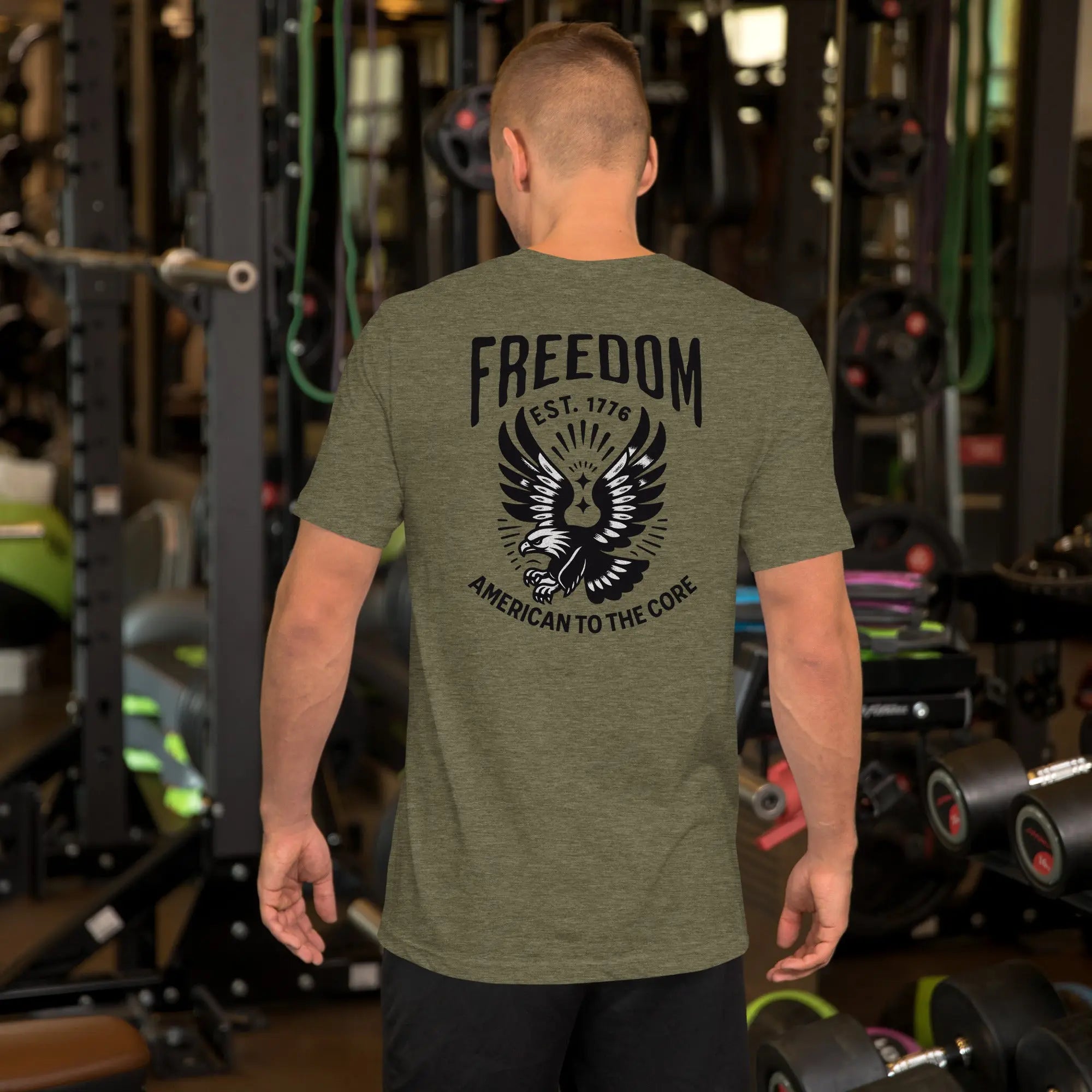 Back of man wearing a olive patriotic t-shirt with an eagle and "freedom est. 1776" text