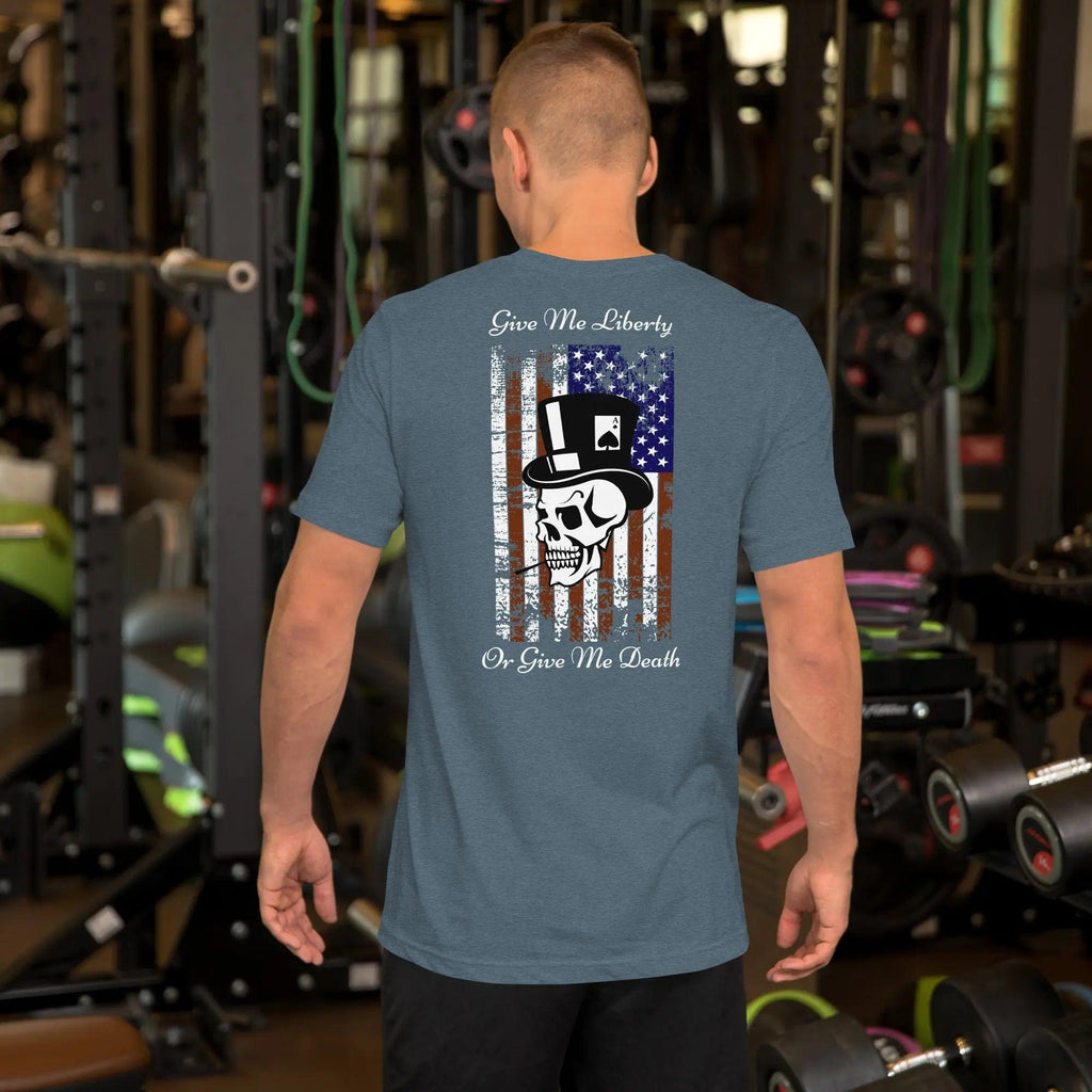 The back of a man wearing a heather slate patriotic T-shirt with a skull over the American flag and the text "Give Me Liberty or Give Me Death."
