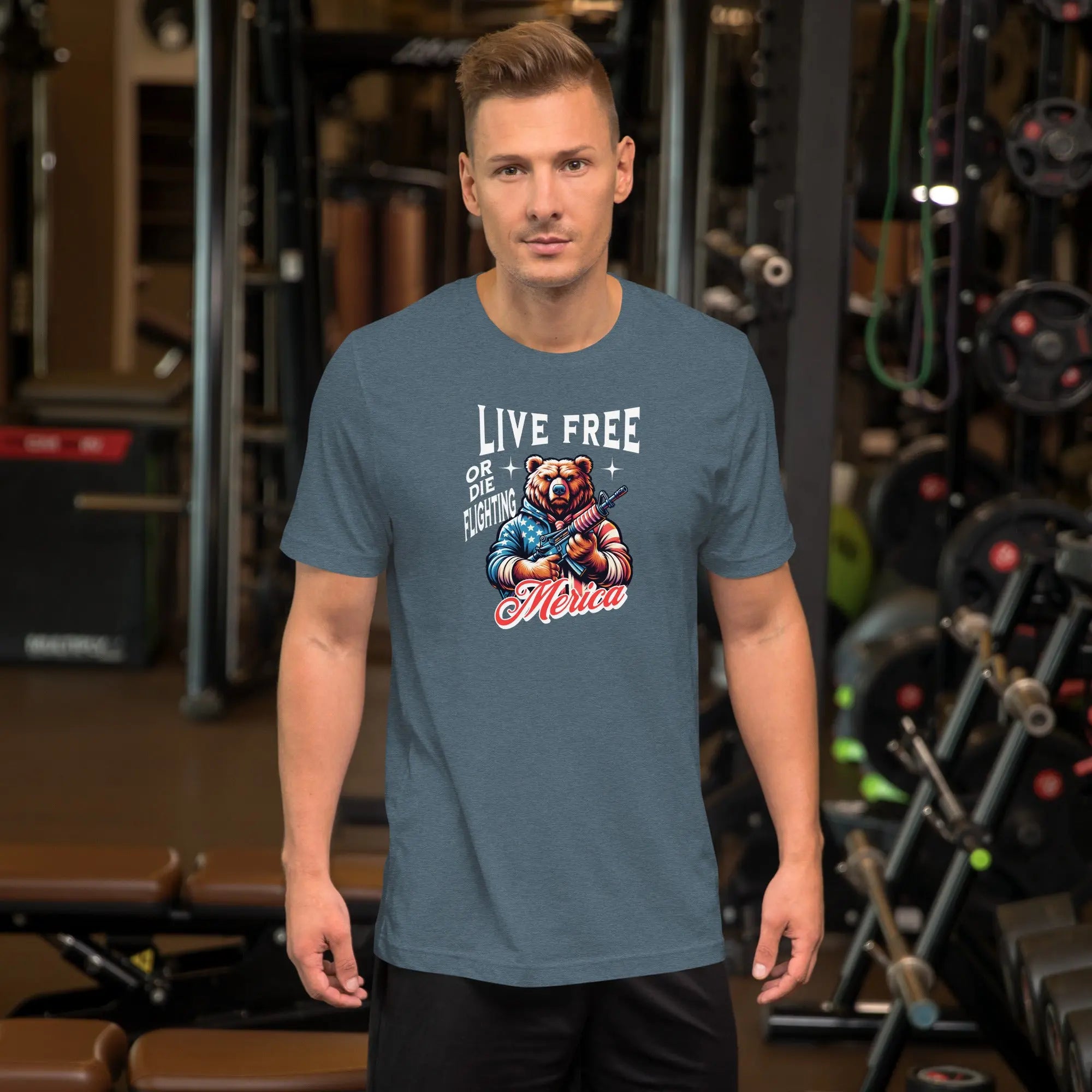 man wearing a heather slate patriotic t-shirt with a image of a bear holding a gun with "live free or die fighting Merica" text