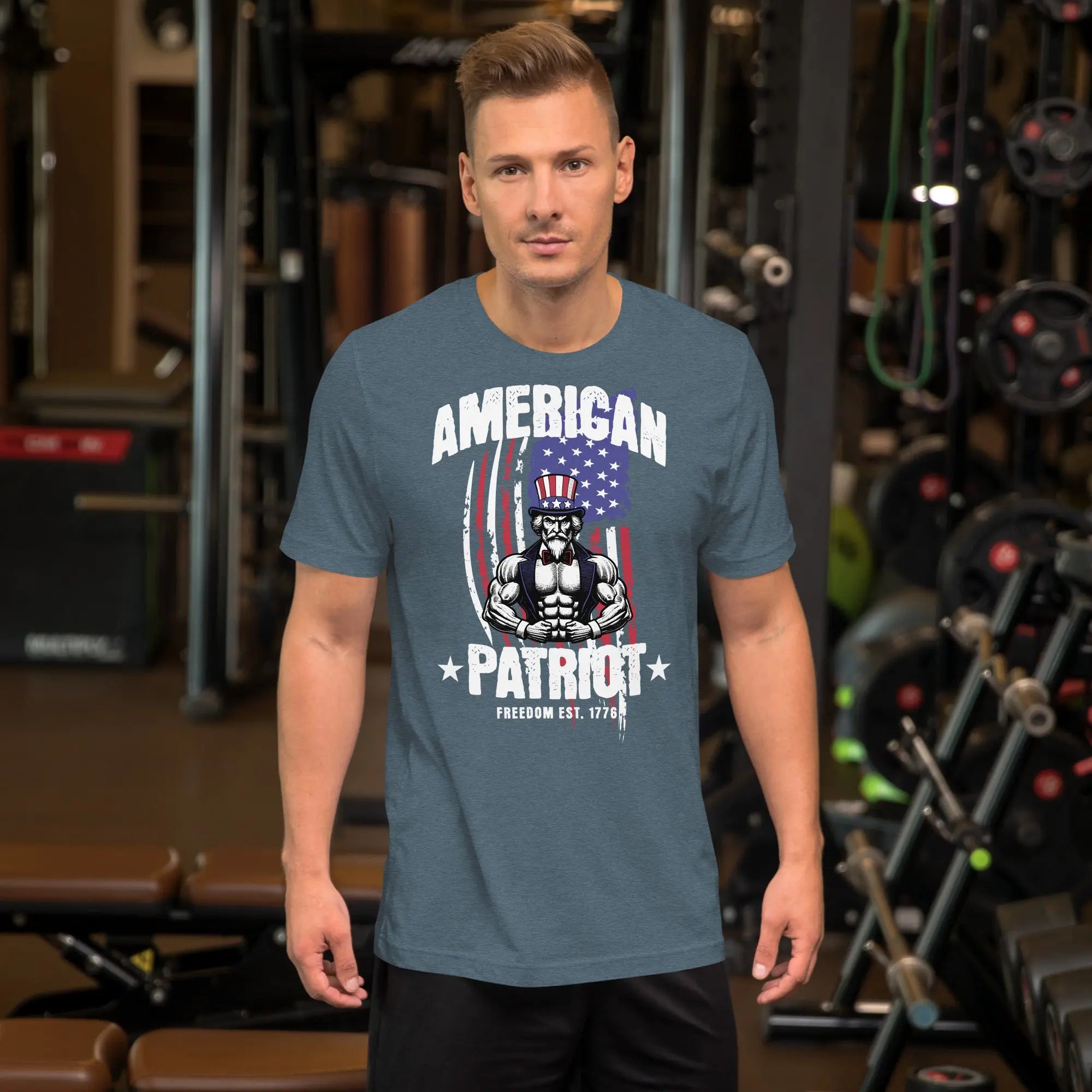A man wearing a heather slate patriotic t-shirt with a muscular Uncle Sam with "American Patriot" text.