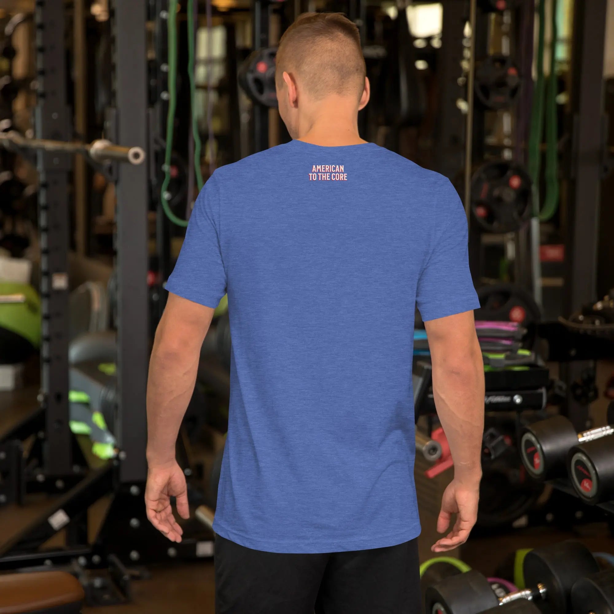 man wearing a blue patriotic t-shirt with text in a gym setting