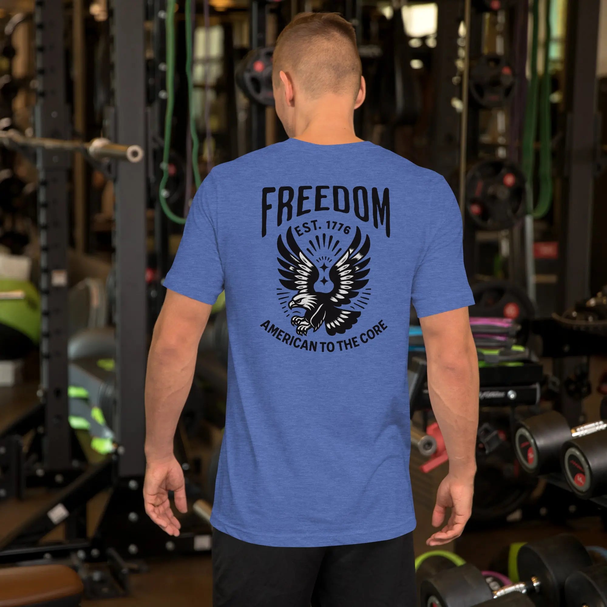 Back of man wearing a royal blue patriotic t-shirt with an eagle and "freedom est. 1776" text