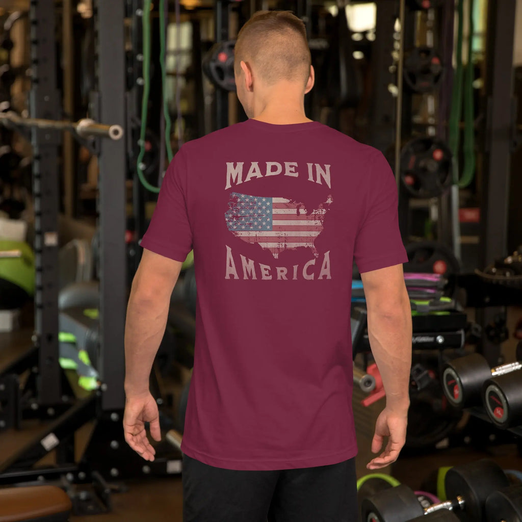 man wearing a maroon patriotic t-shirt with "made in america" text. A silhouette of america with the american flag in it. 