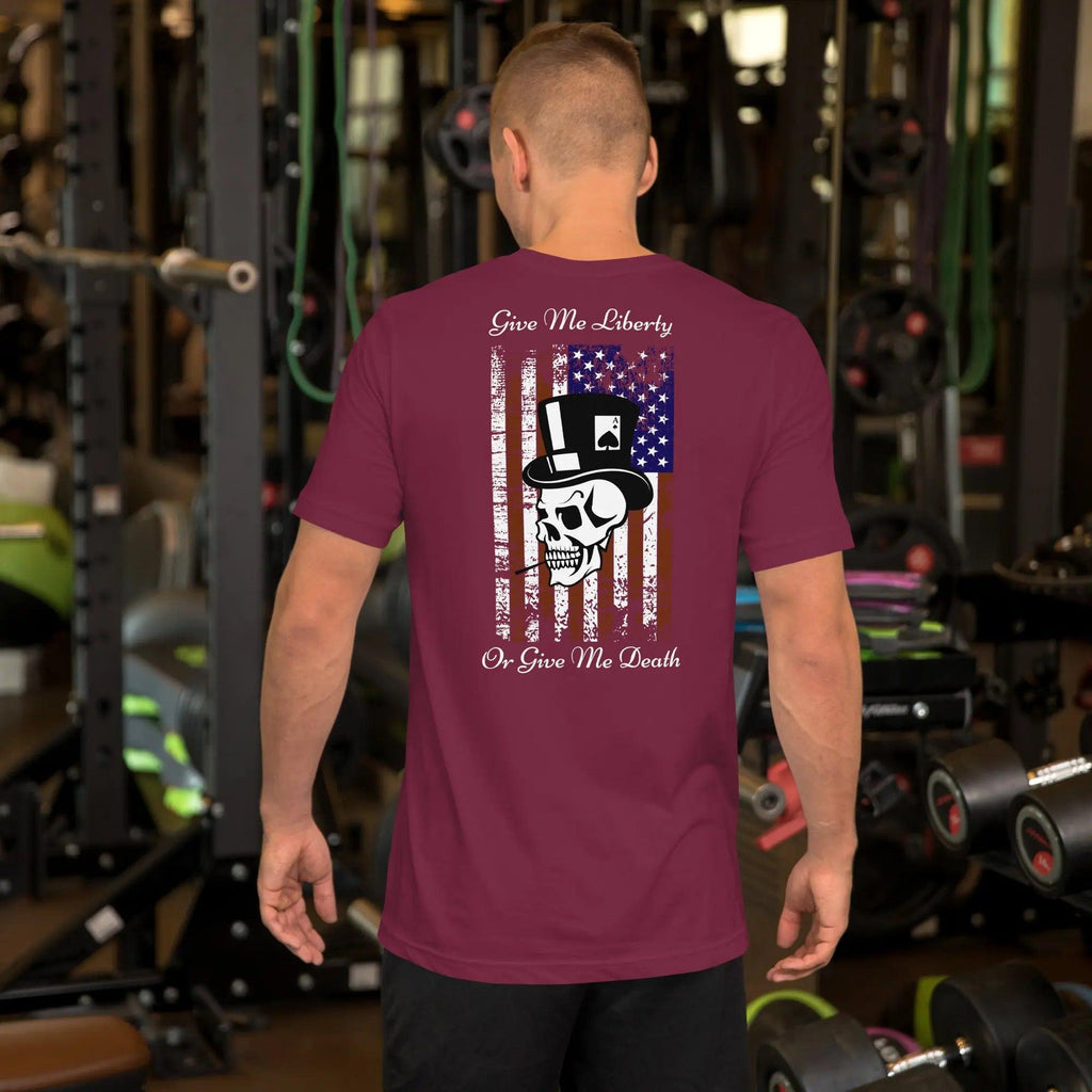 The back of a man wearing a maroon patriotic T-shirt with a skull over the American flag and the text "Give Me Liberty Or Give Me Death."