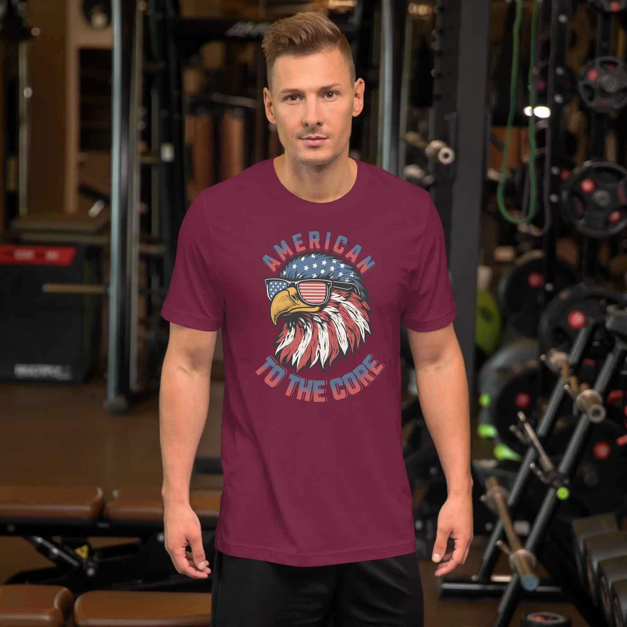 A man wearing a maroon patriotic t-shirt with an eagle head with "American to the core" text.