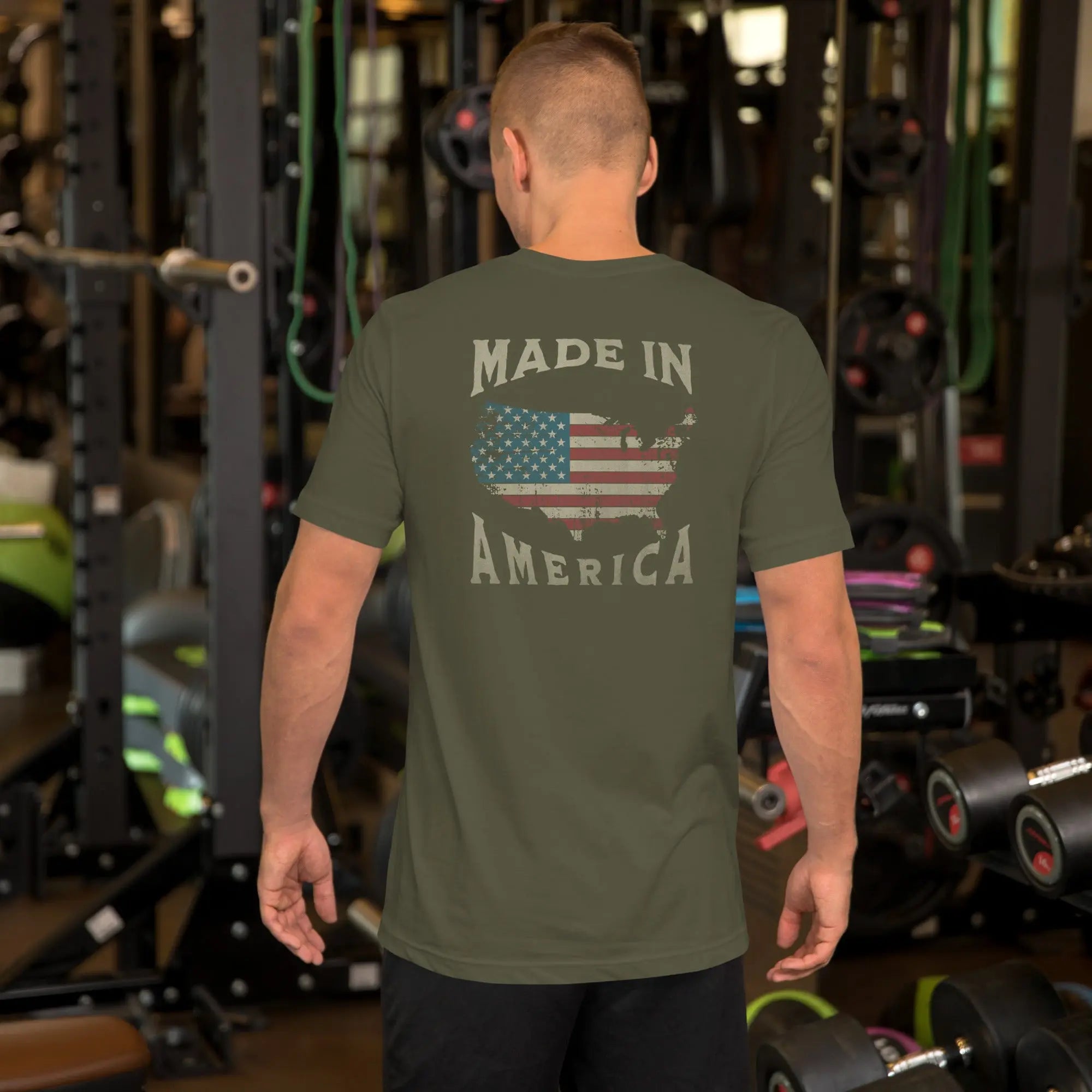 man wearing a military green patriotic t-shirt with "made in america" text. A silhouette of america with the american flag in it. 