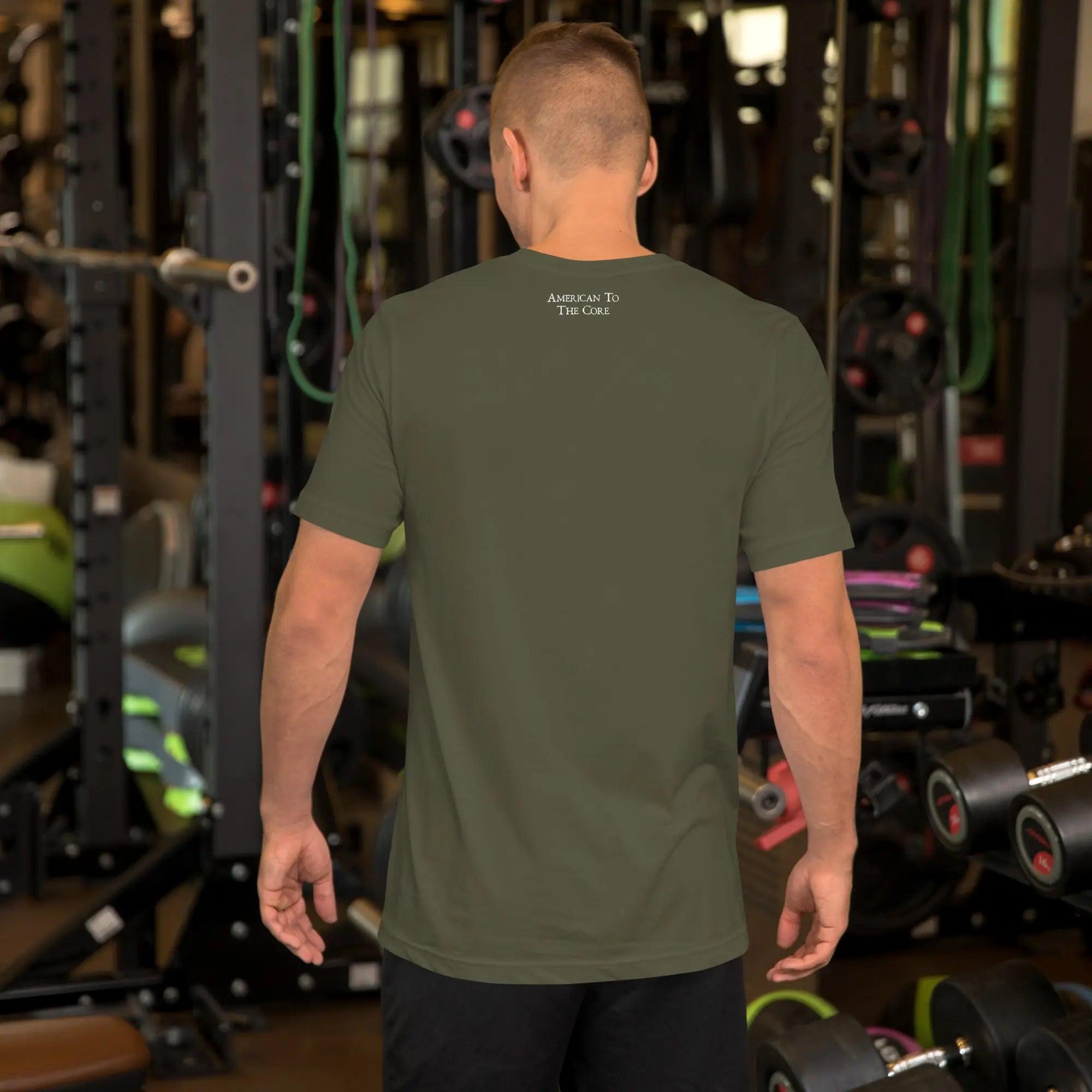 Back of a man wearing a military green patriotic t-shirt. With the text "American To The Core." 