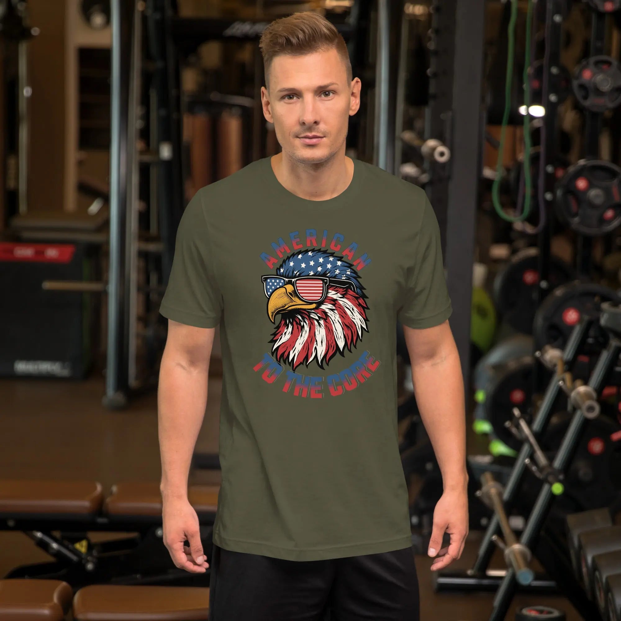 A man wearing a military green patriotic t-shirt with an eagle head with "American to the core" text.